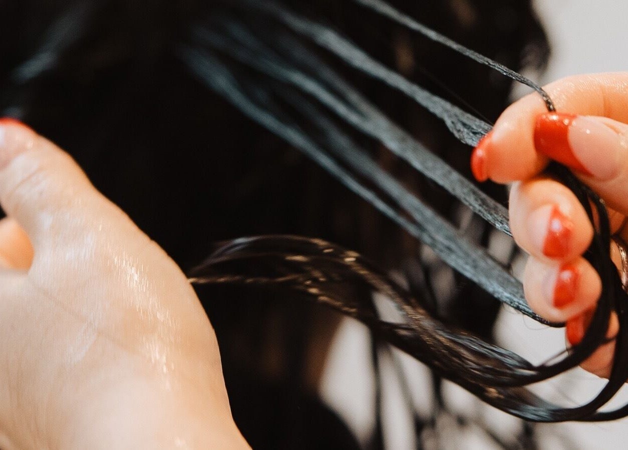 Close-up of hands treating hair at Naomi Cuts Curls, Kelowna, British Columbia, CA.
