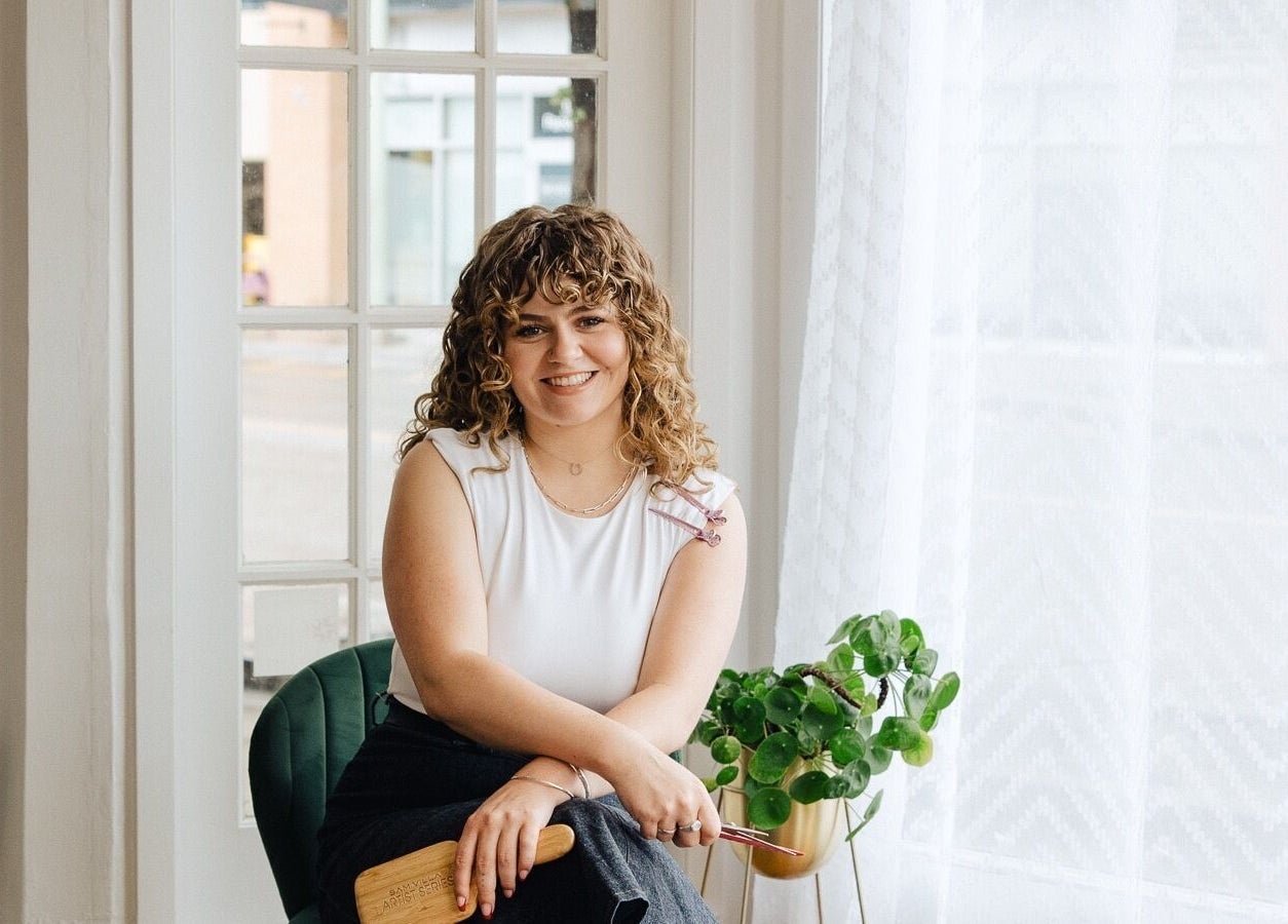 Relaxing interior at Naomi Cuts Curls, Kelowna, British Columbia, CA, featuring a welcoming stylist in cozy setting.