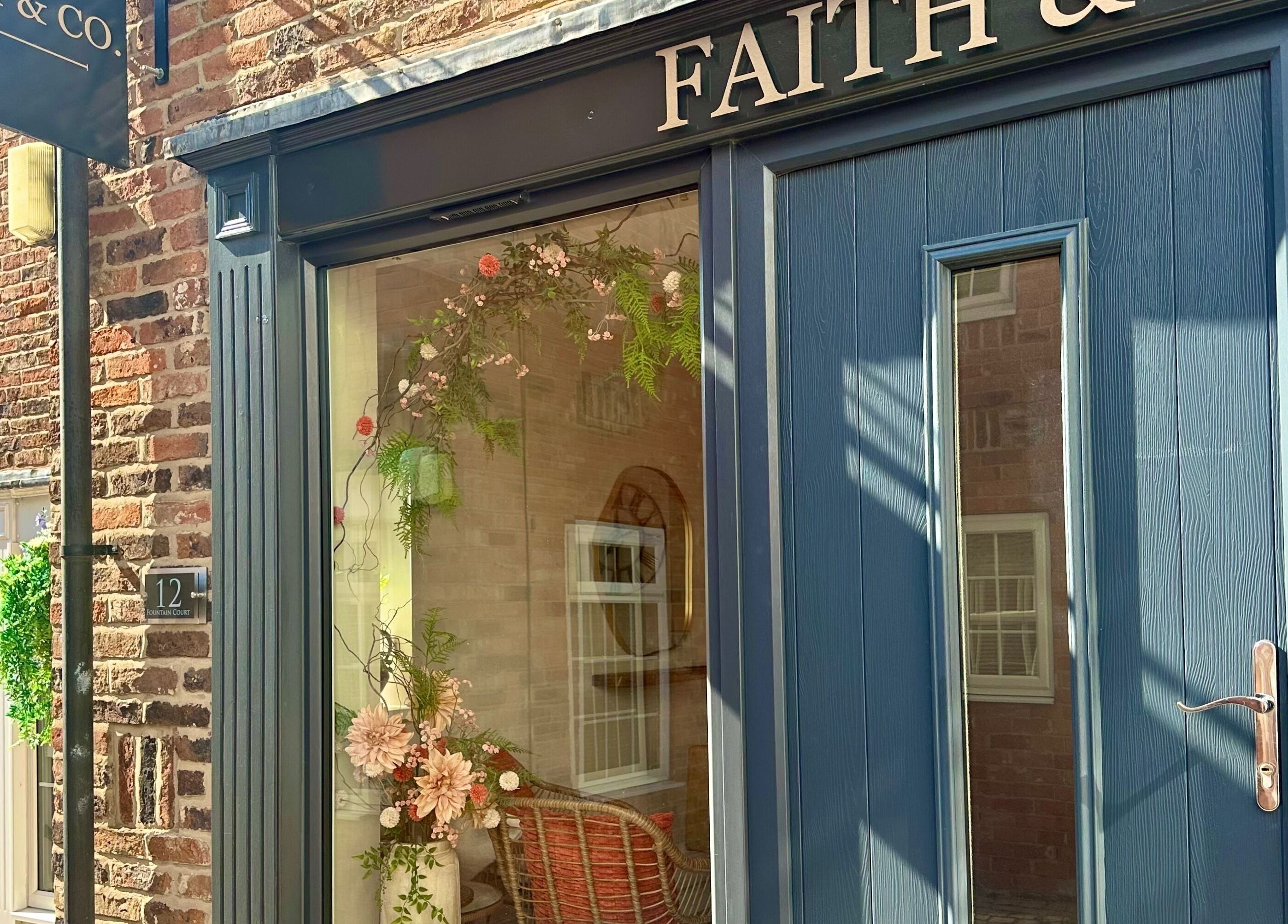 Entrance of Faith & Co. with floral decor at 12 Epworth, England, GB.