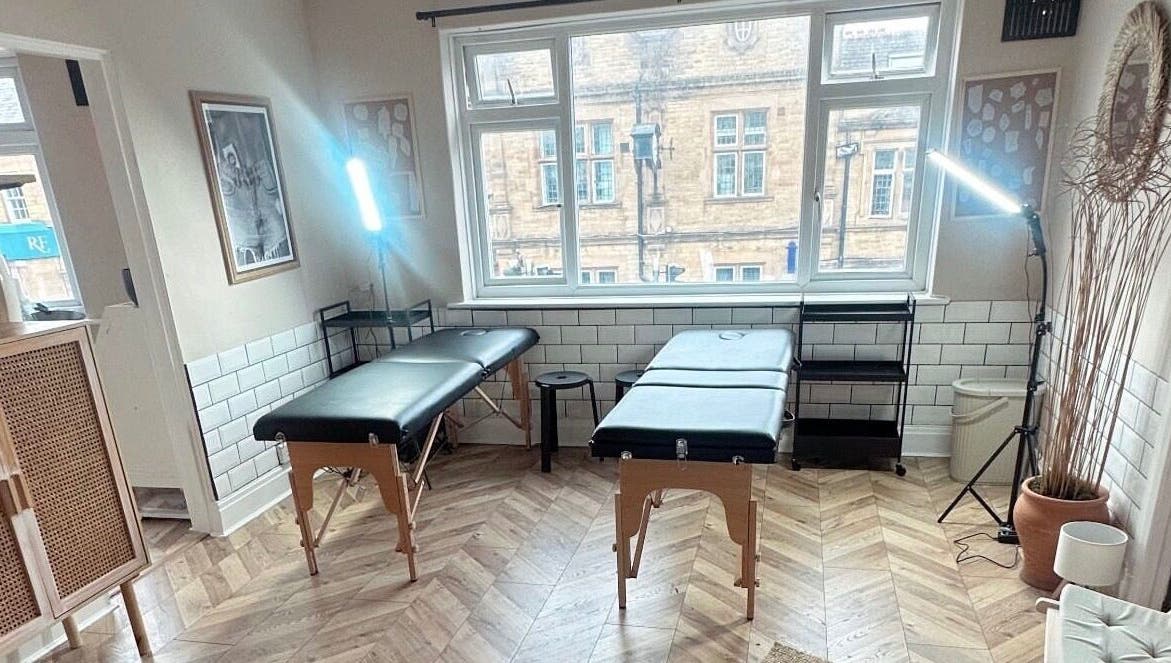Modern, light-filled tattoo studio at Jadene Tattoos, Leeds, England, GB. Features two black tables and stylish decor.