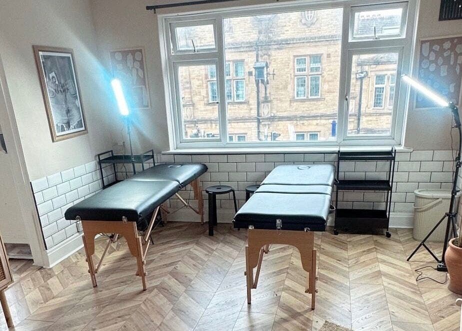 Modern, light-filled tattoo studio at Jadene Tattoos, Leeds, England, GB. Features two black tables and stylish decor.
