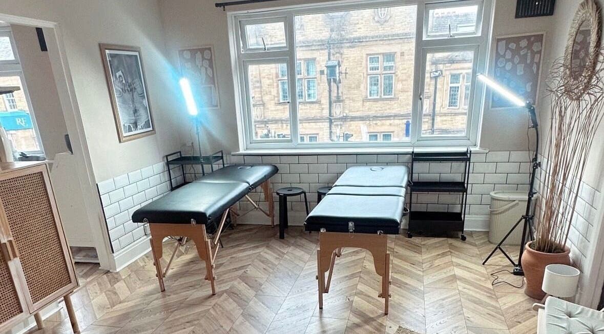 Modern, light-filled tattoo studio at Jadene Tattoos, Leeds, England, GB. Features two black tables and stylish decor.