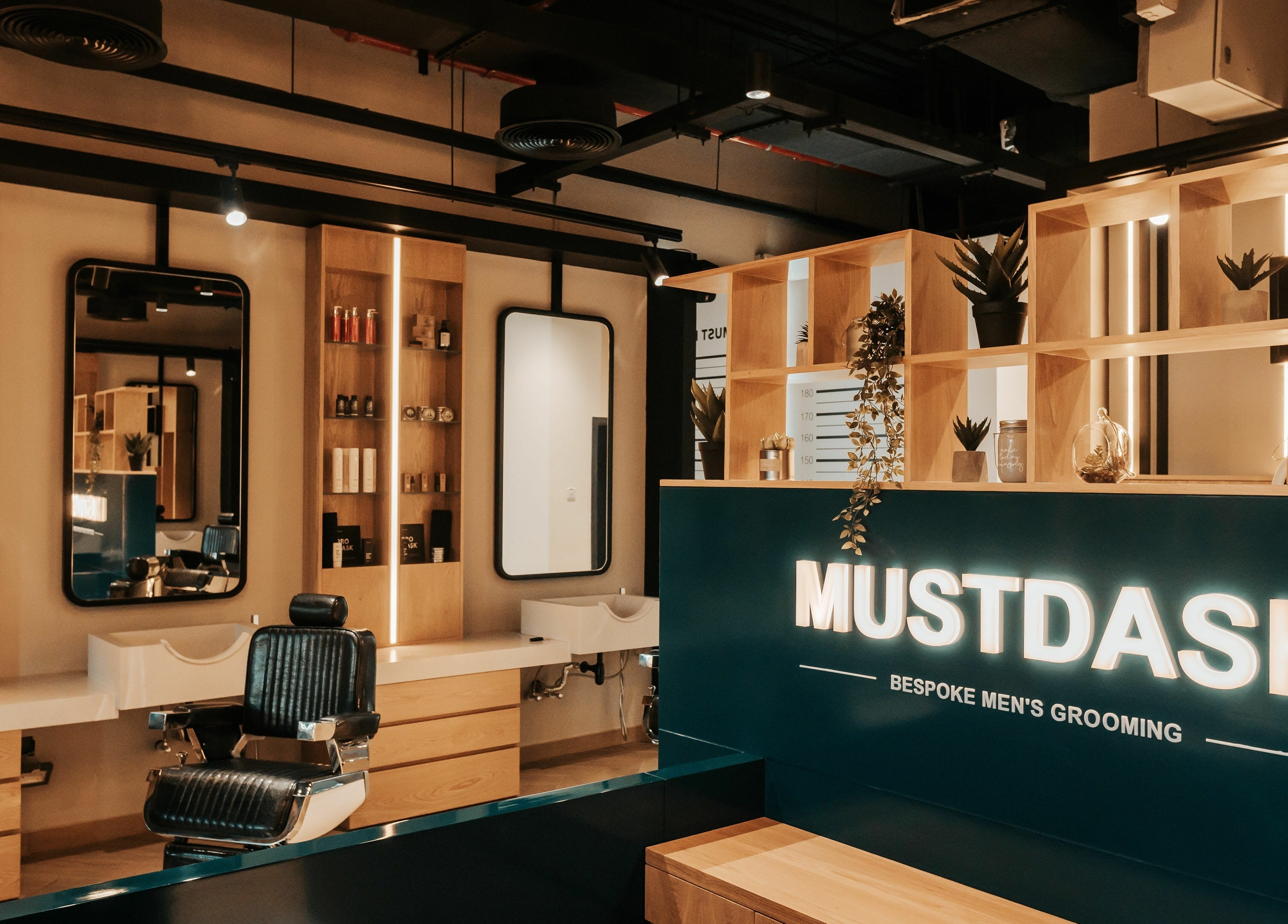 Stylish interior of Must Dash - Bespoke Men’s Grooming in Dubai, AE featuring modern barber chairs and decor.
