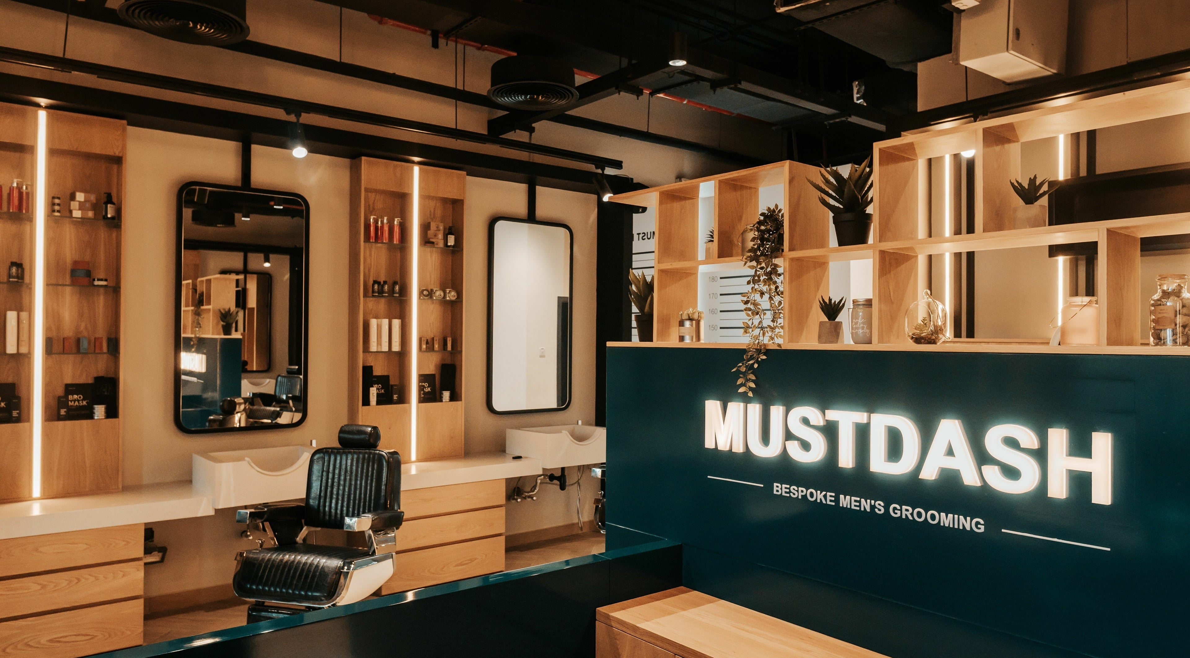 Stylish interior of Must Dash - Bespoke Men’s Grooming in Dubai, AE featuring modern barber chairs and decor.