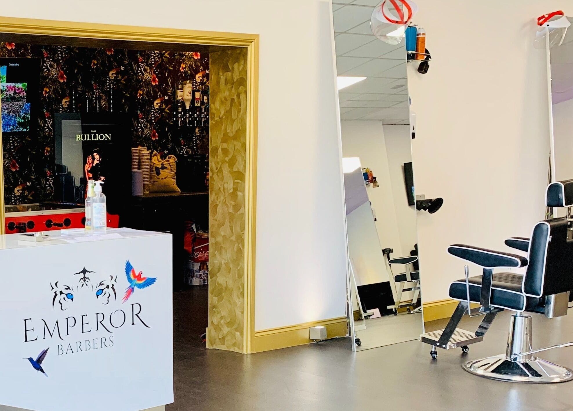 Interior of Emperor Barbers in Dunstable, England, showcasing modern barber chair and sleek decor.