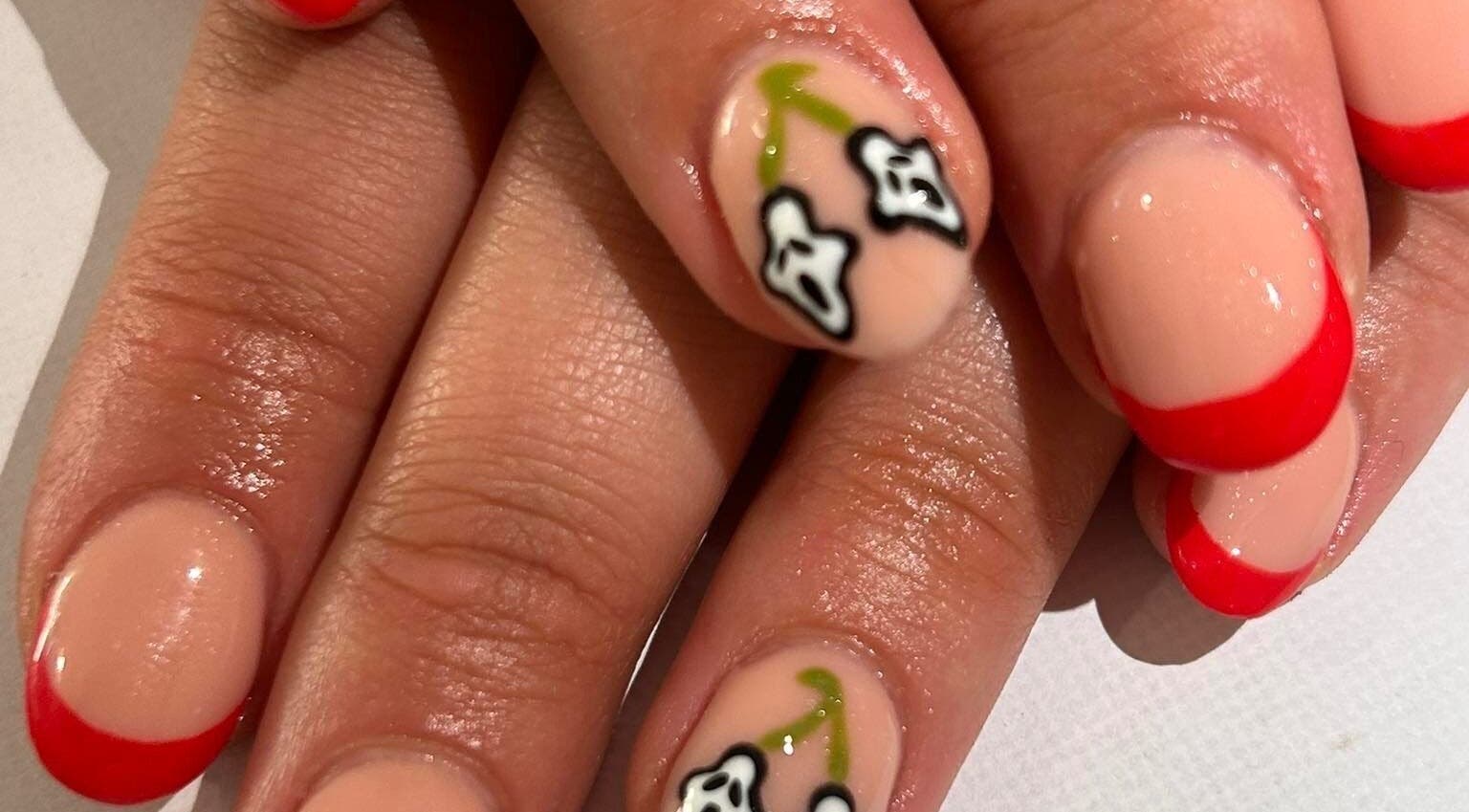 Elegant floral nail art with red tips at The Luxury Nail Bar, Galashiels, Scotland, GB.