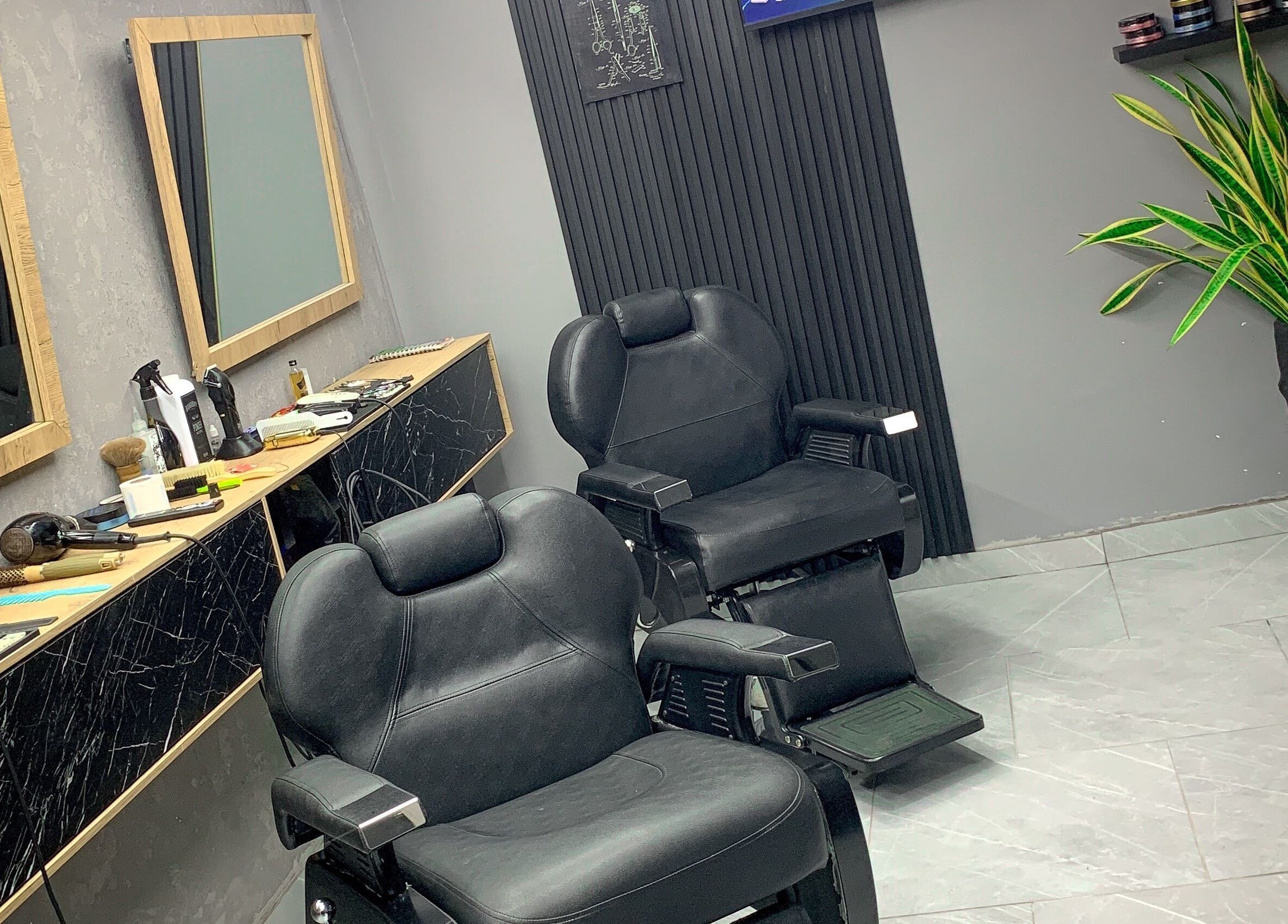 Interior moderno de Johns Barber Studio, Montería, Córdoba, CO, con sillas de peluquería y espejos elegantes.