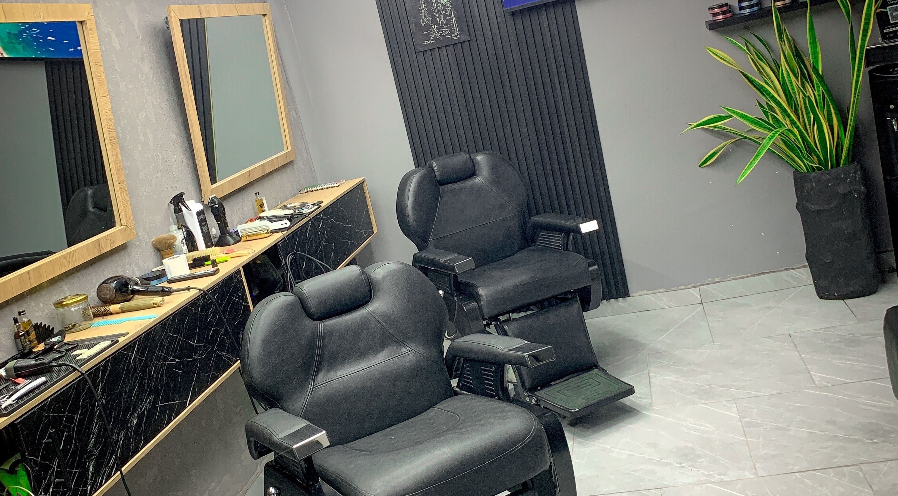 Interior moderno de Johns Barber Studio, Montería, Córdoba, CO, con sillas de peluquería y espejos elegantes.