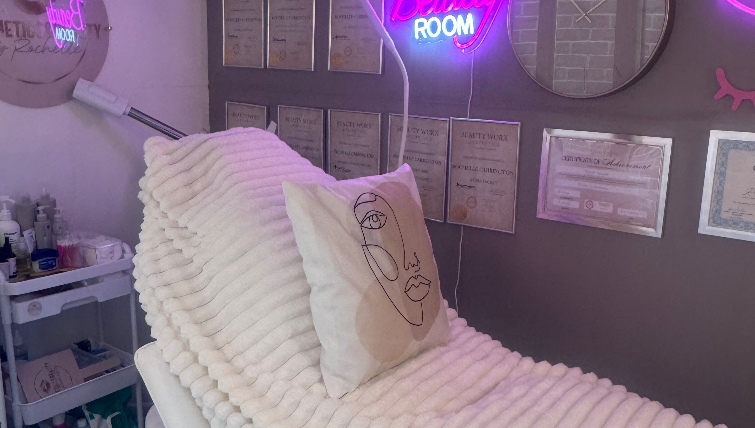 Cozy treatment room at Aesthetics & Beauty By Rochelle, Croydon, England, GB, with soft lighting and certificates.
