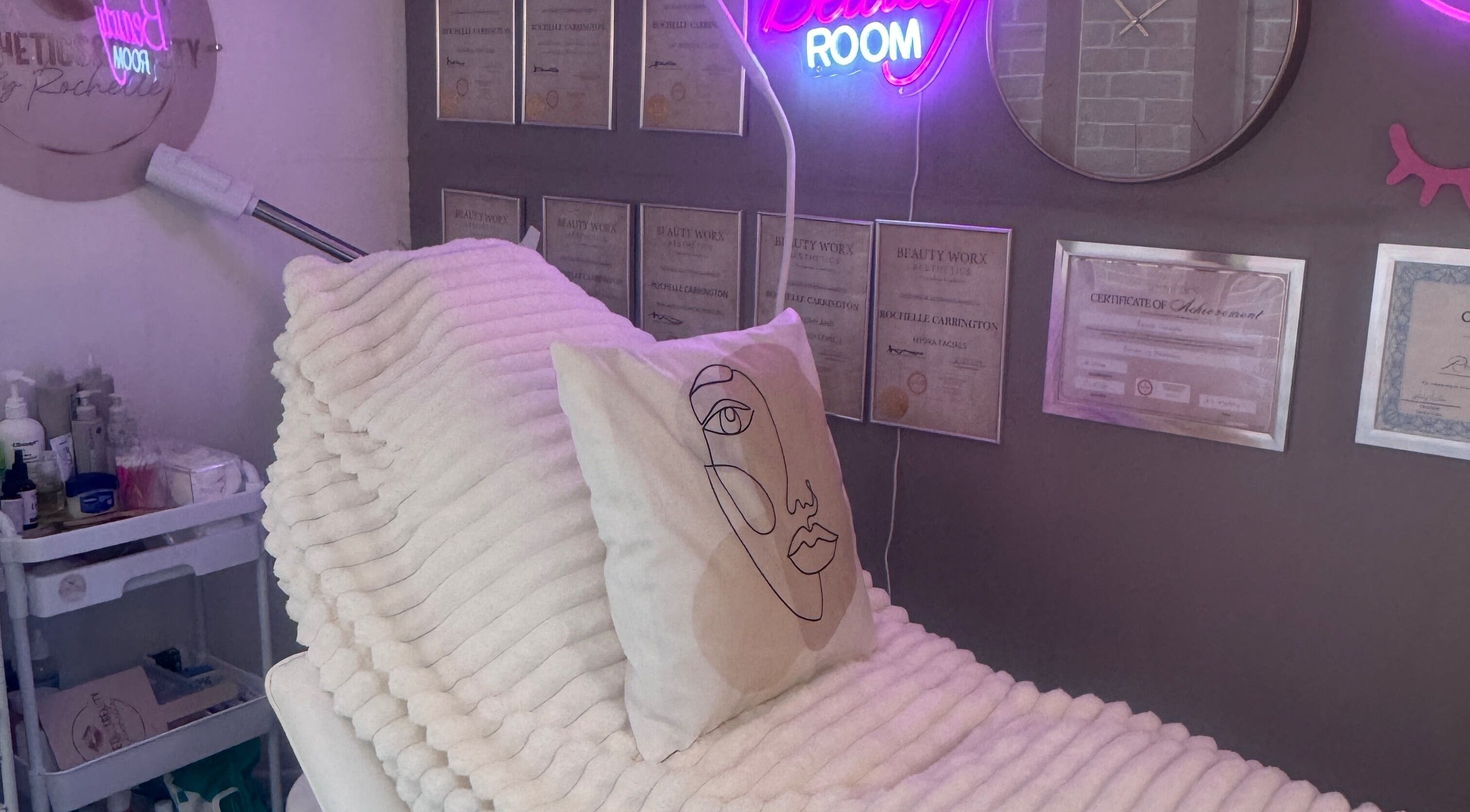 Cozy treatment room at Aesthetics & Beauty By Rochelle, Croydon, England, GB, with soft lighting and certificates.