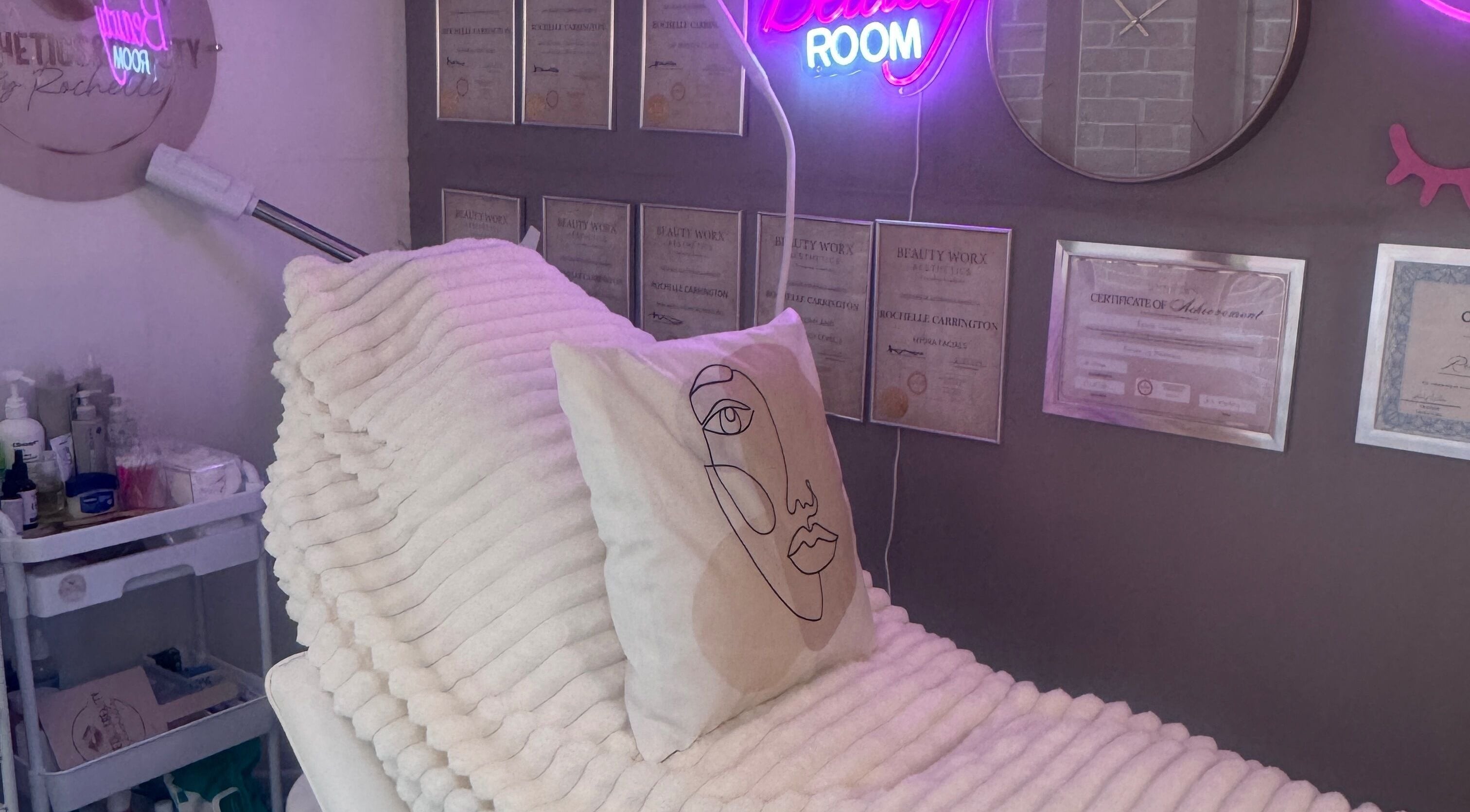 Cozy treatment room at Aesthetics & Beauty By Rochelle, Croydon, England, GB, with soft lighting and certificates.