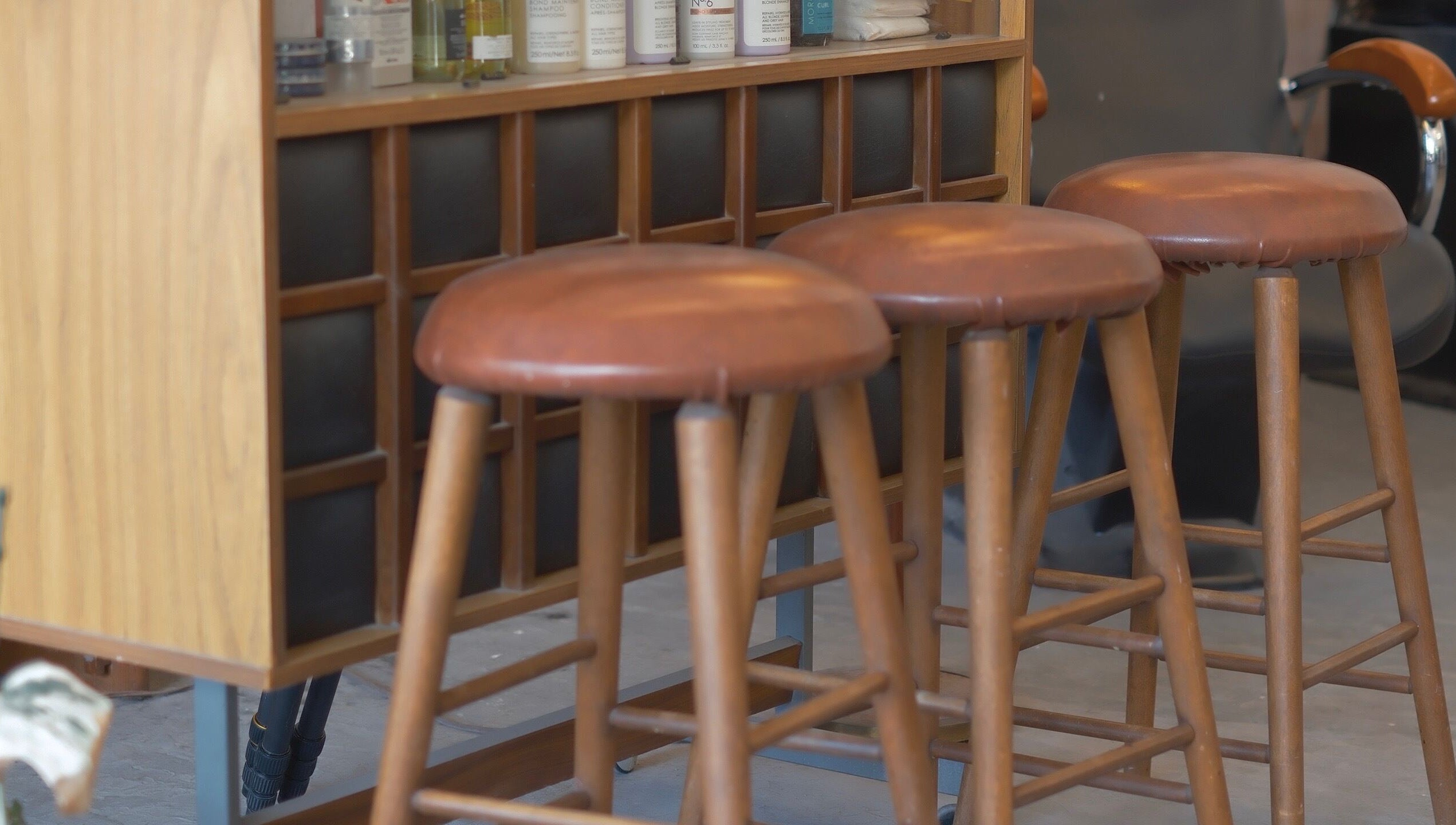 Elegant wooden bar stools at cafune.west salon in Vancouver, British Columbia, CA, offering a relaxing ambiance.