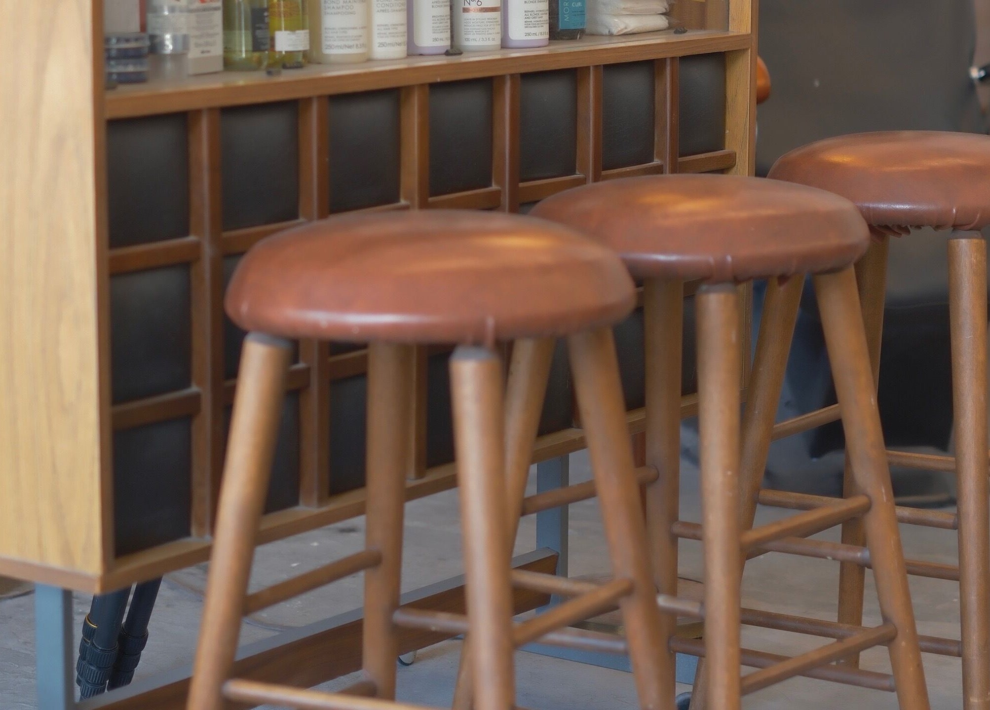 Elegant wooden bar stools at cafune.west salon in Vancouver, British Columbia, CA, offering a relaxing ambiance.