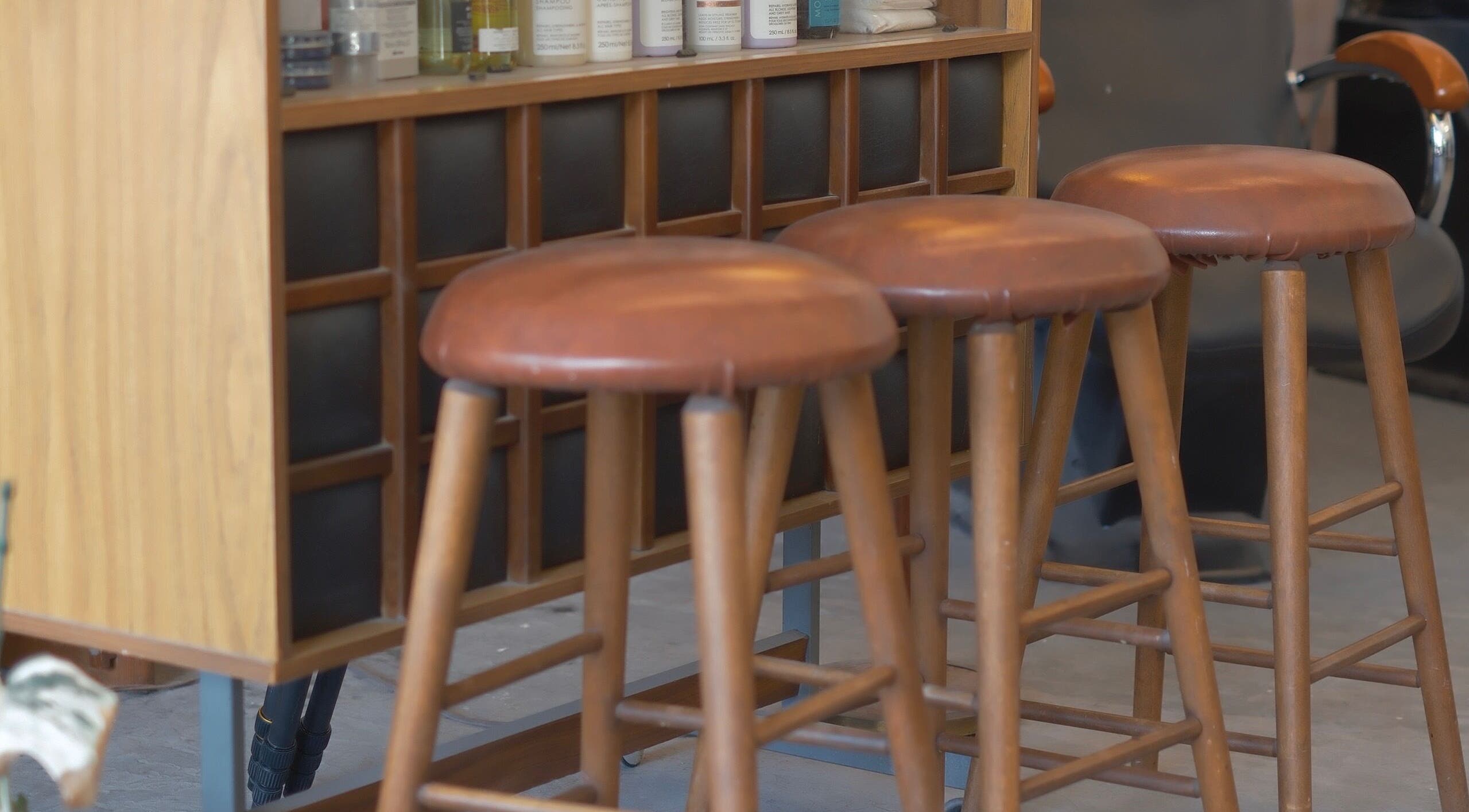 Elegant wooden bar stools at cafune.west salon in Vancouver, British Columbia, CA, offering a relaxing ambiance.