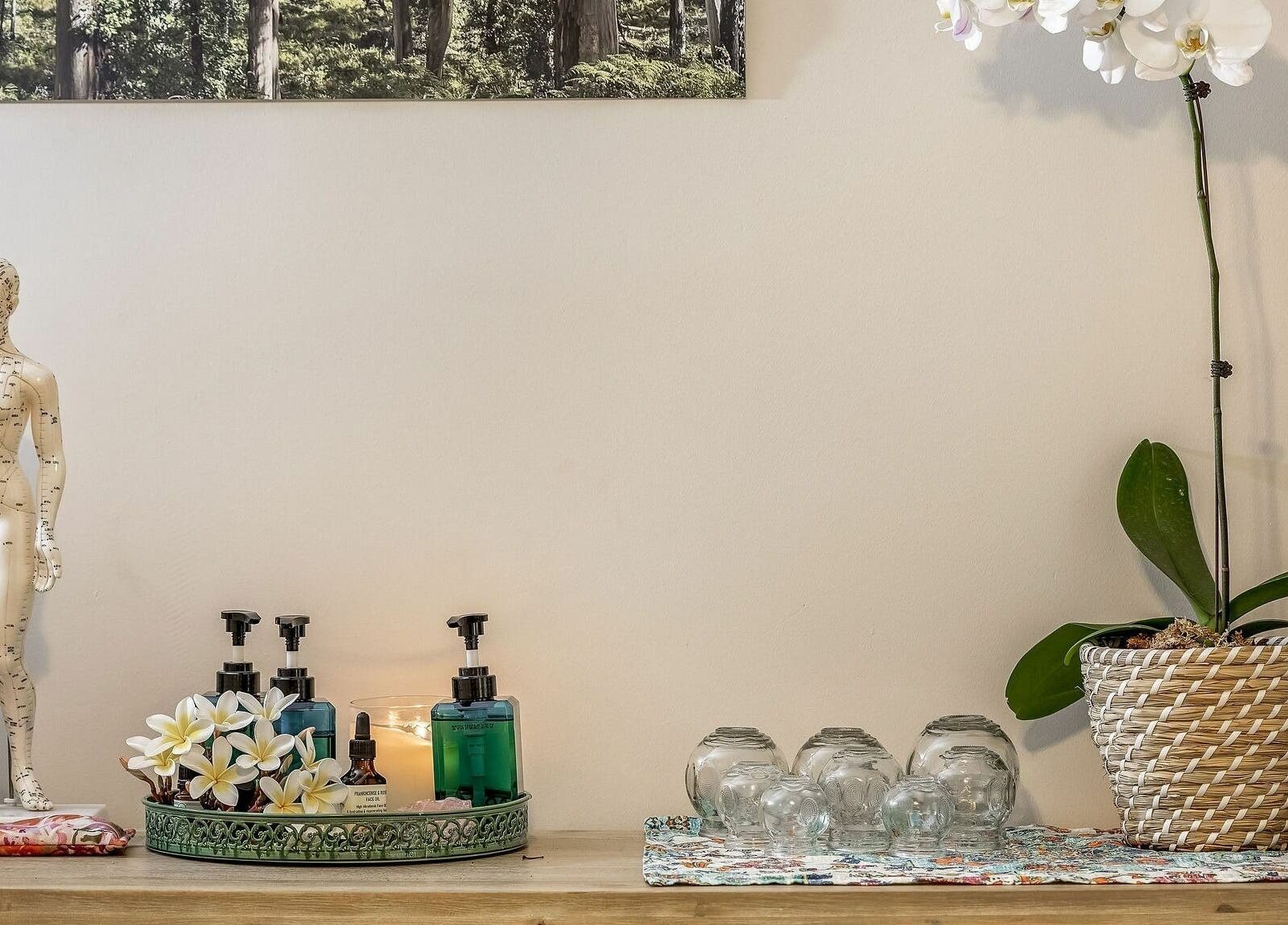 Elegant wellness decor featuring a model, oils, and an orchid at Dharma Massage & Movement, Abbey, Western Australia, AU.