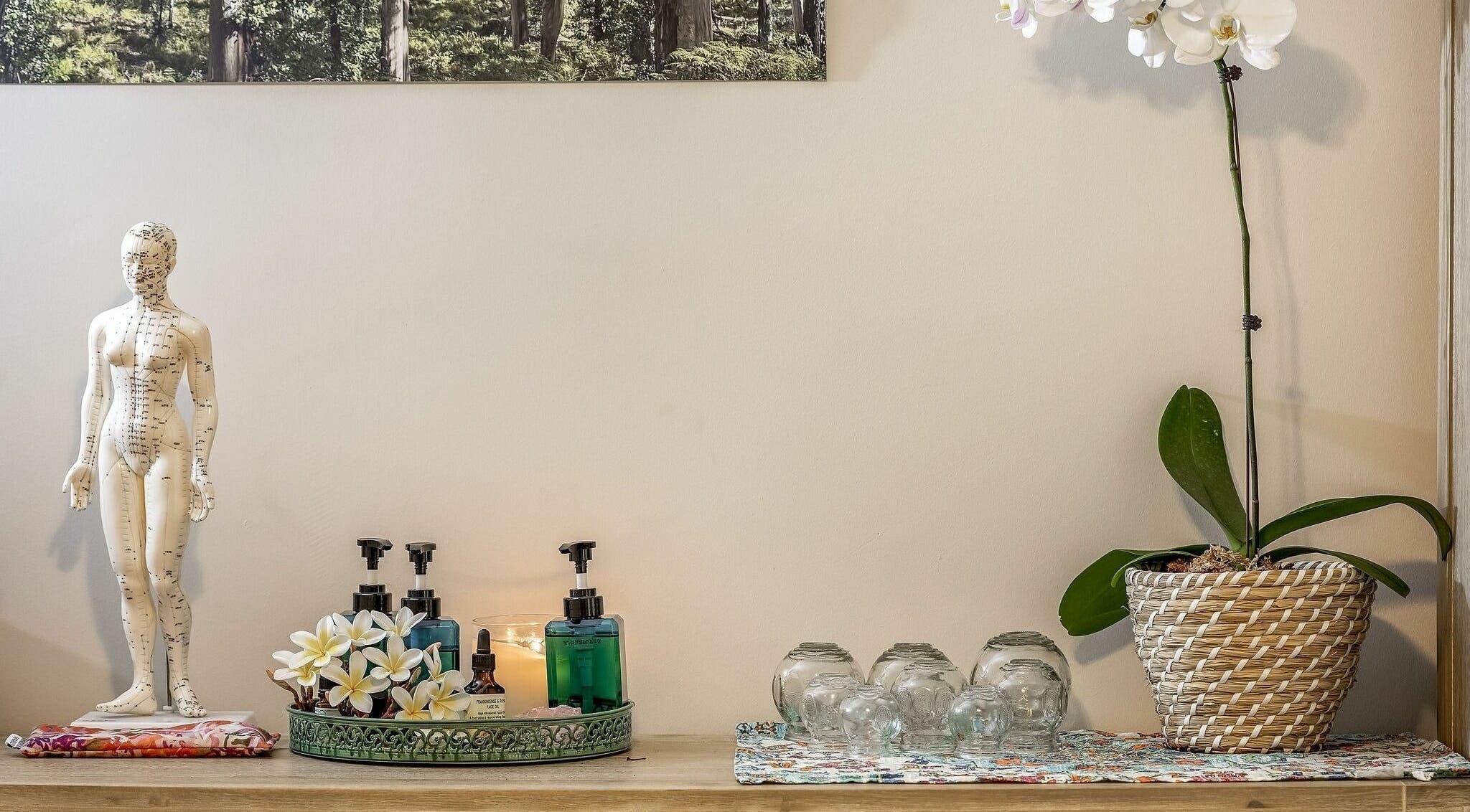 Elegant wellness decor featuring a model, oils, and an orchid at Dharma Massage & Movement, Abbey, Western Australia, AU.