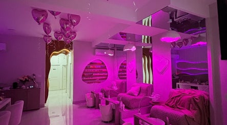Elegant pink-lit interior of Haven Beauty House in Kingston, St. Andrew Parish, JM with cozy seating.