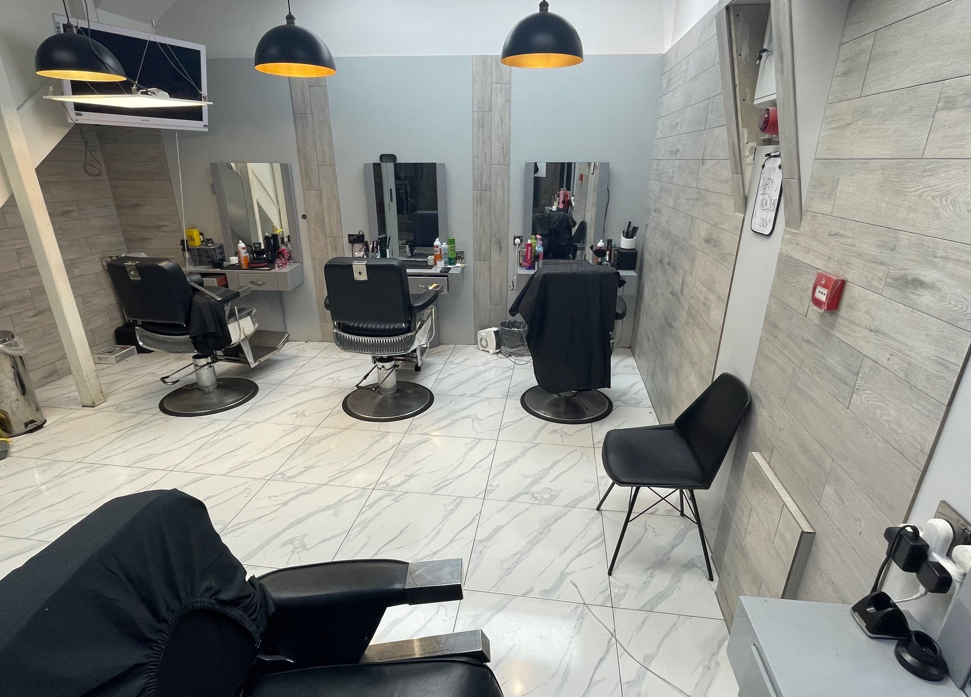 Modern interior of Lk Cutzz salon in Peterborough, England, GB with stylish barber chairs and sleek design.