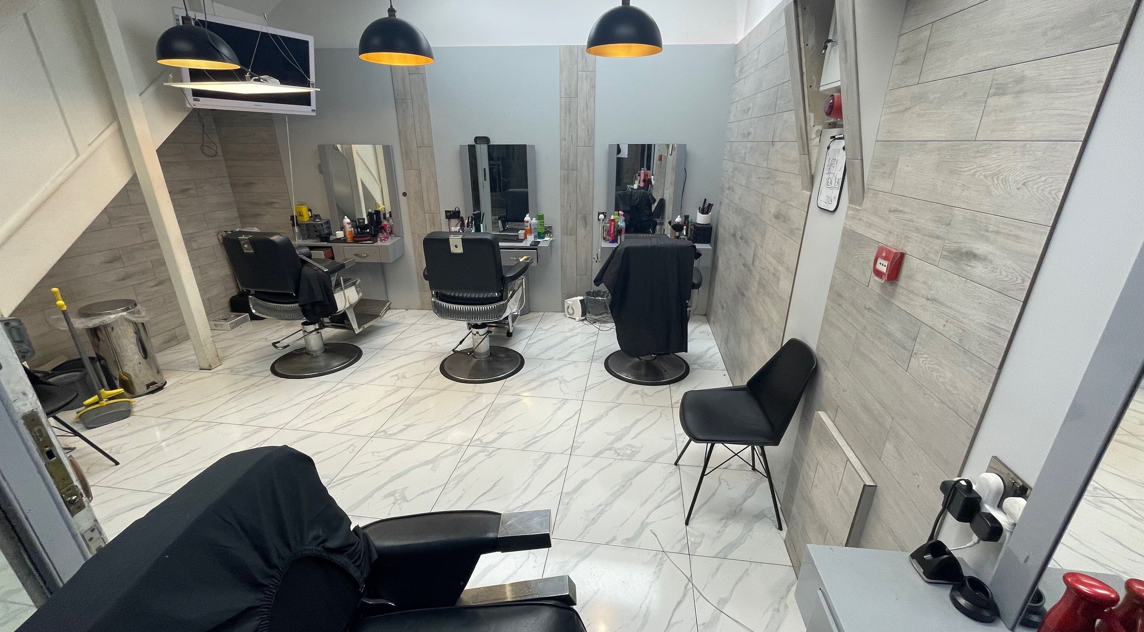 Modern interior of Lk Cutzz salon in Peterborough, England, GB with stylish barber chairs and sleek design.