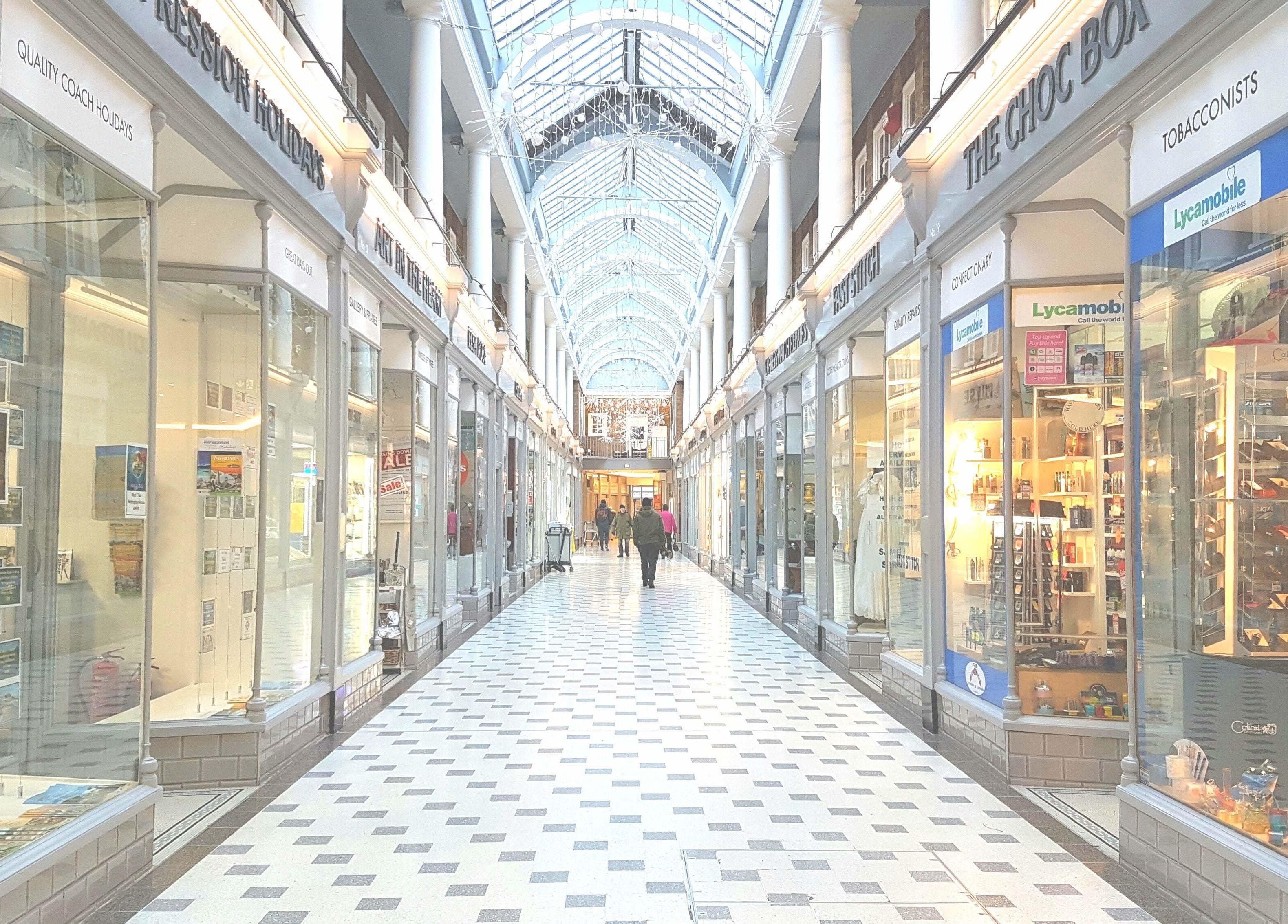 Charming arcade near Lk Cutzz, Peterborough, England, GB, showcasing elegant shops in a stylish setting.