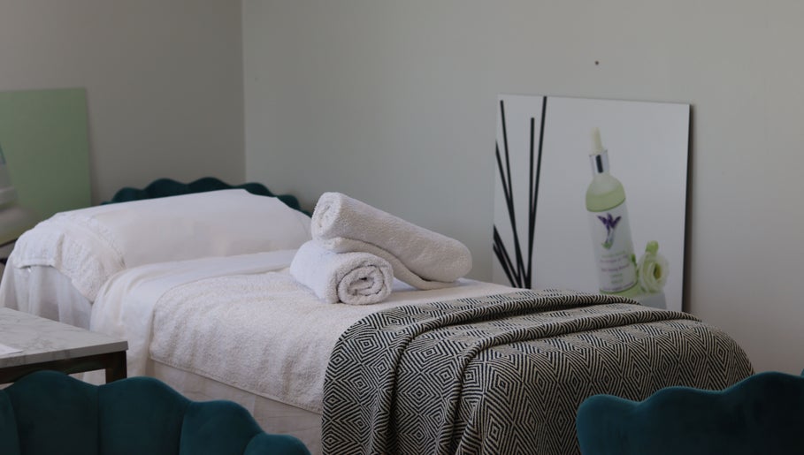 Luxurious treatment bed at Jennifer Young Wellness Clinic, Madeley, England, GB, with plush towels and calming decor.