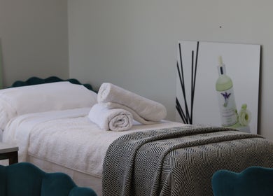 Luxurious treatment bed at Jennifer Young Wellness Clinic, Madeley, England, GB, with plush towels and calming decor.