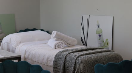 Luxurious treatment bed at Jennifer Young Wellness Clinic, Madeley, England, GB, with plush towels and calming decor.