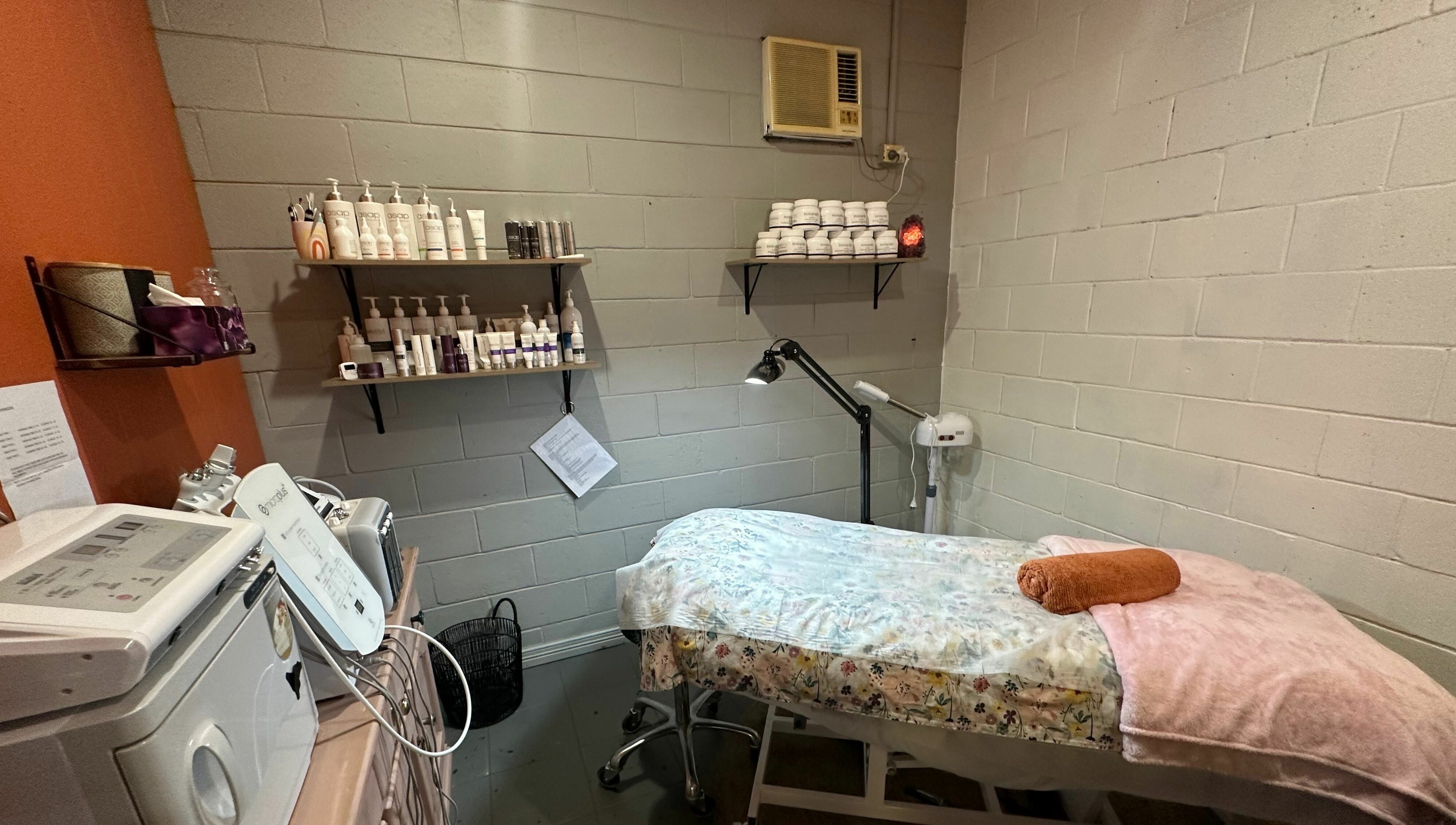 Relaxing spa room at JD’s Hair Affair in Clermont, Queensland, AU, featuring a cozy treatment bed and skincare products.
