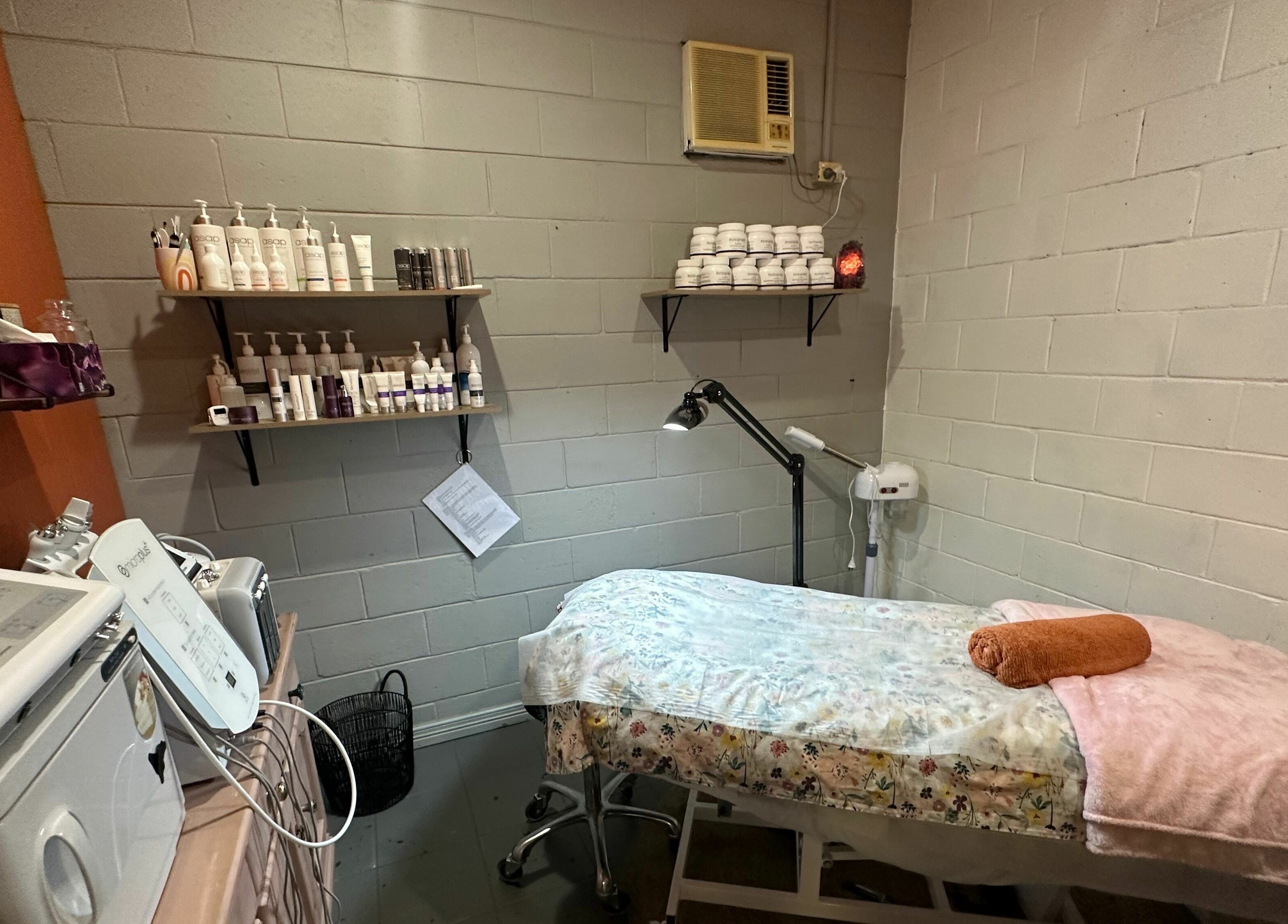 Relaxing spa room at JD’s Hair Affair in Clermont, Queensland, AU, featuring a cozy treatment bed and skincare products.