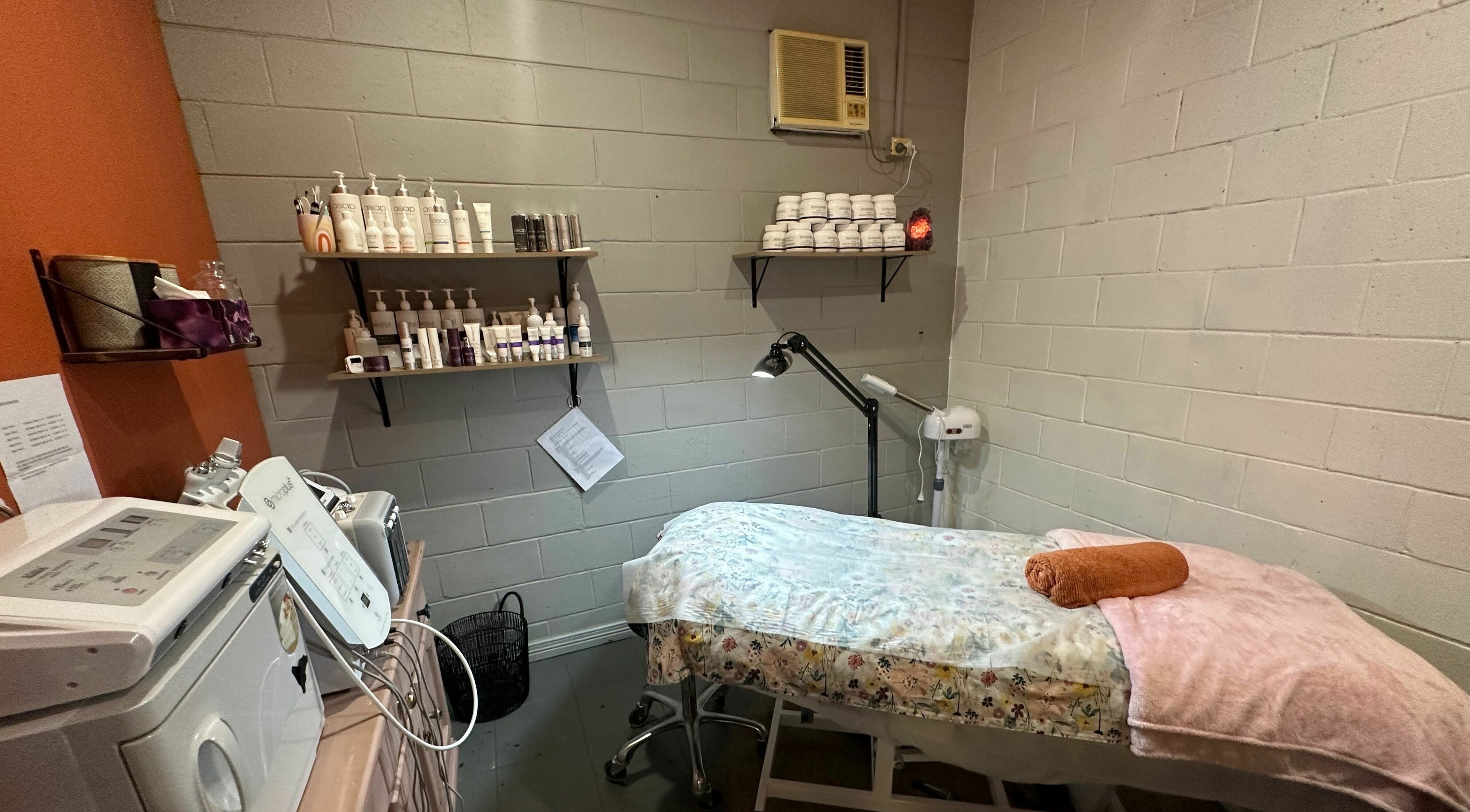 Relaxing spa room at JD’s Hair Affair in Clermont, Queensland, AU, featuring a cozy treatment bed and skincare products.
