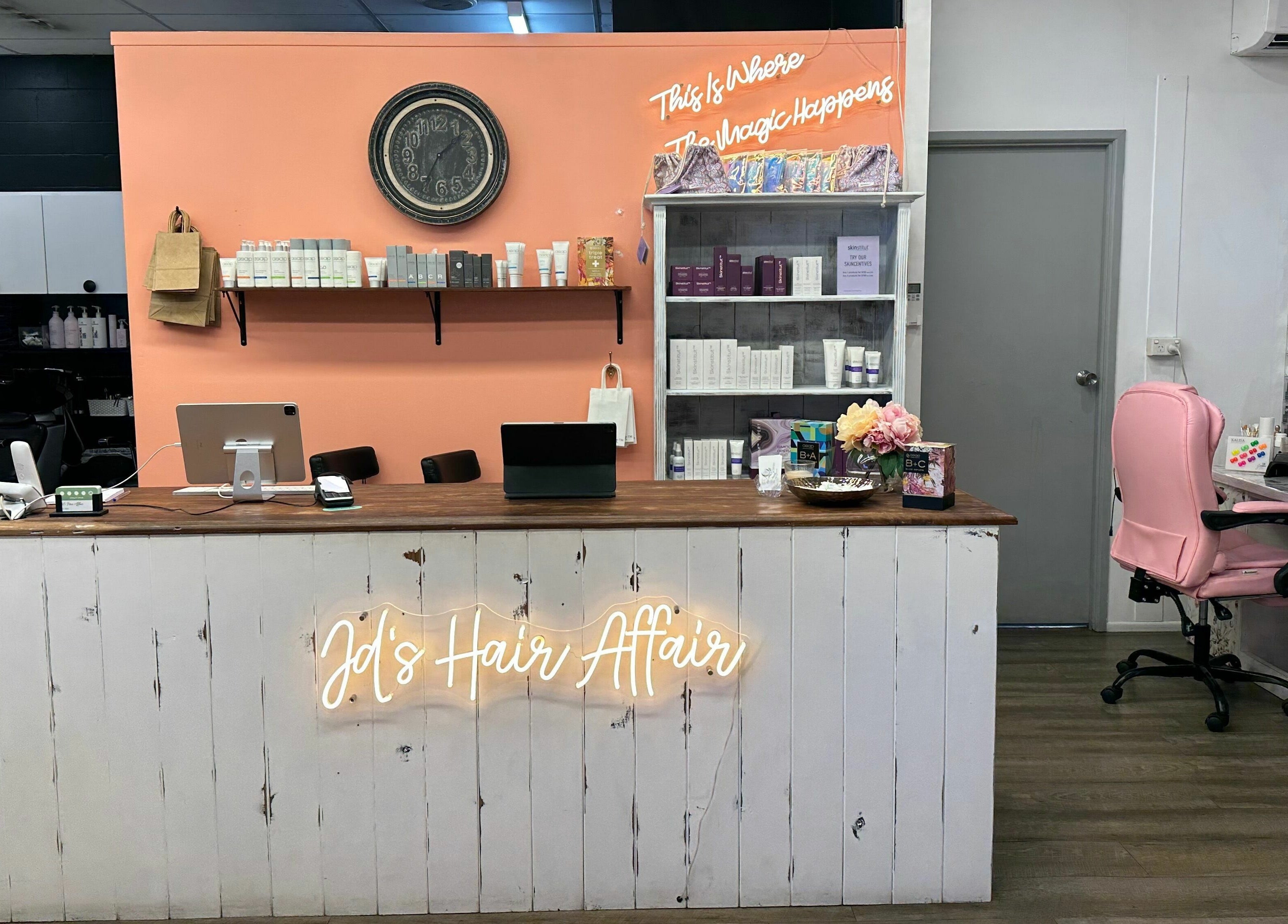 Modern reception desk at JD’s Hair Affair, Clermont, Queensland, AU, with shelves of beauty products.