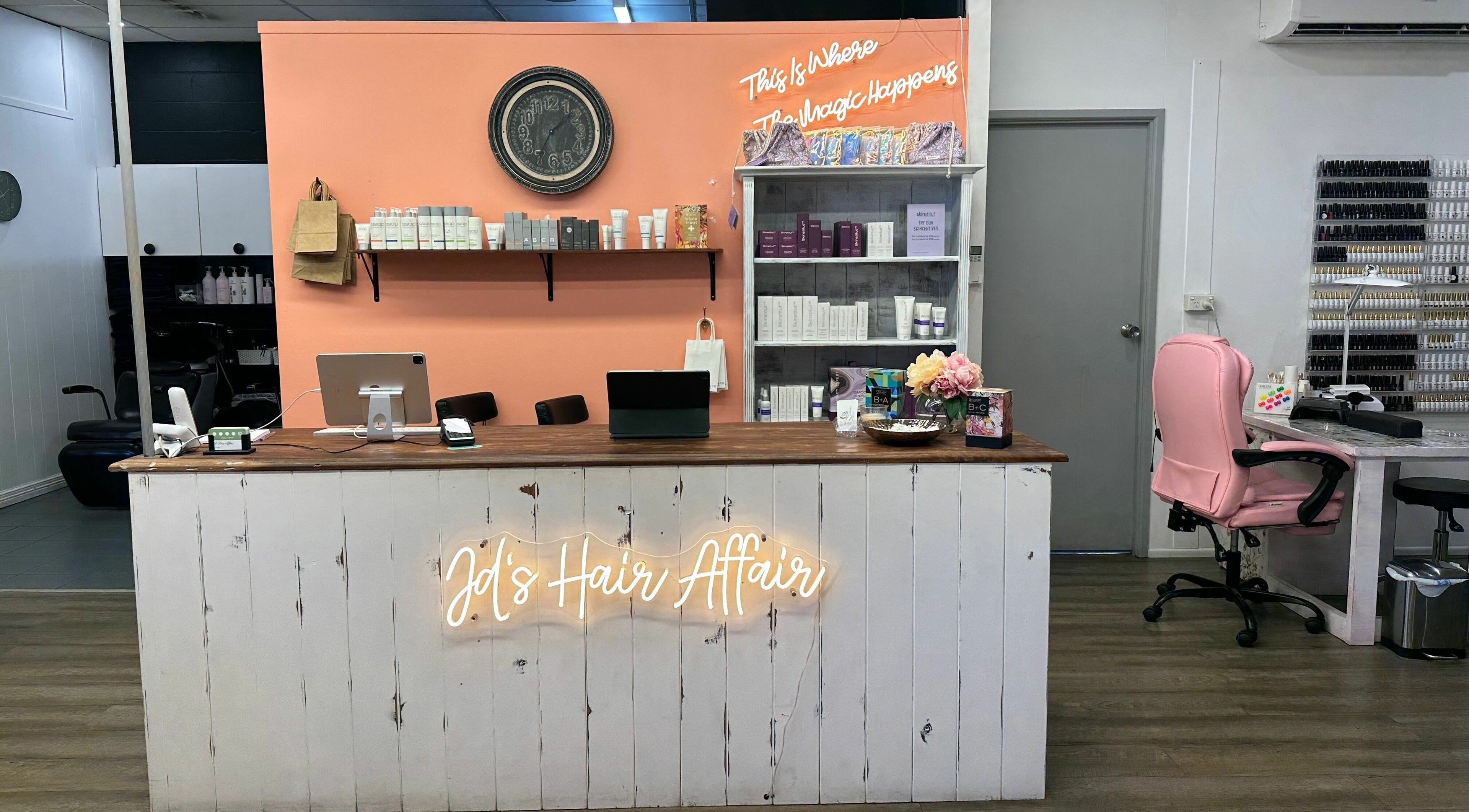 Modern reception desk at JD’s Hair Affair, Clermont, Queensland, AU, with shelves of beauty products.