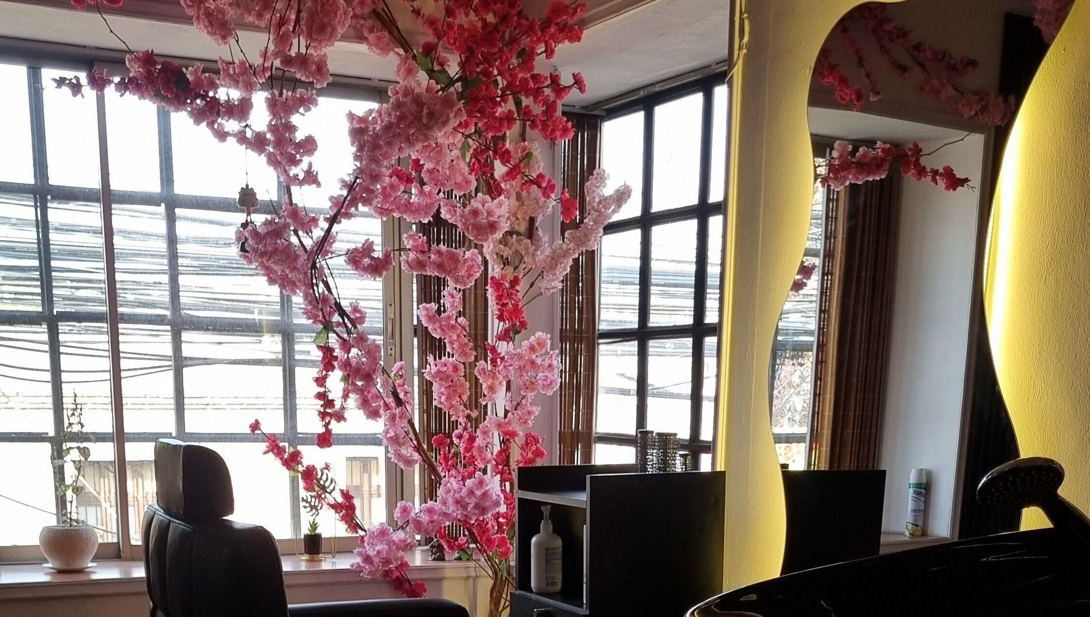 Interior de Sily Beauty Brand en San Miguel, Región Metropolitana, CL con flores rosadas decorativas y espejo elegante.