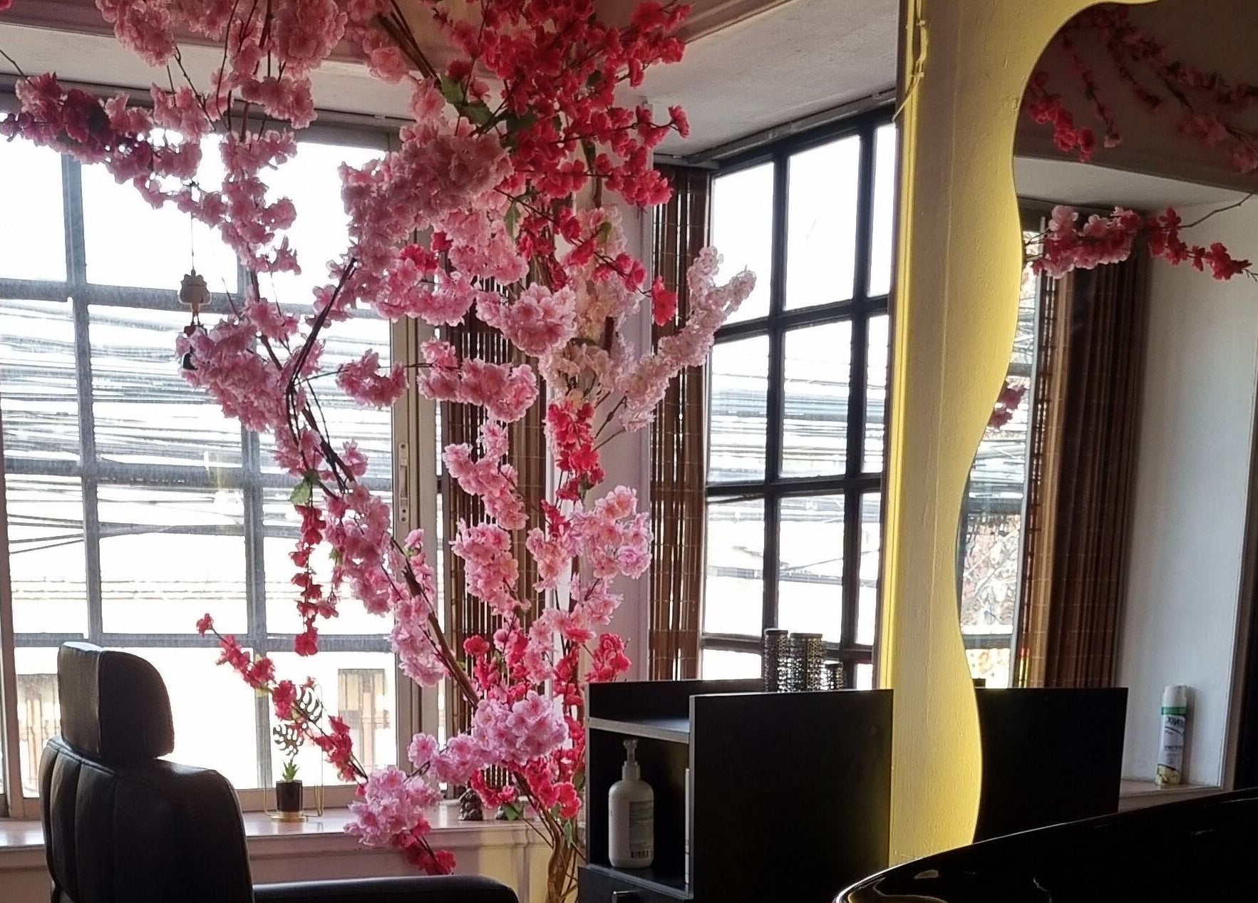 Interior de Sily Beauty Brand en San Miguel, Región Metropolitana, CL con flores rosadas decorativas y espejo elegante.