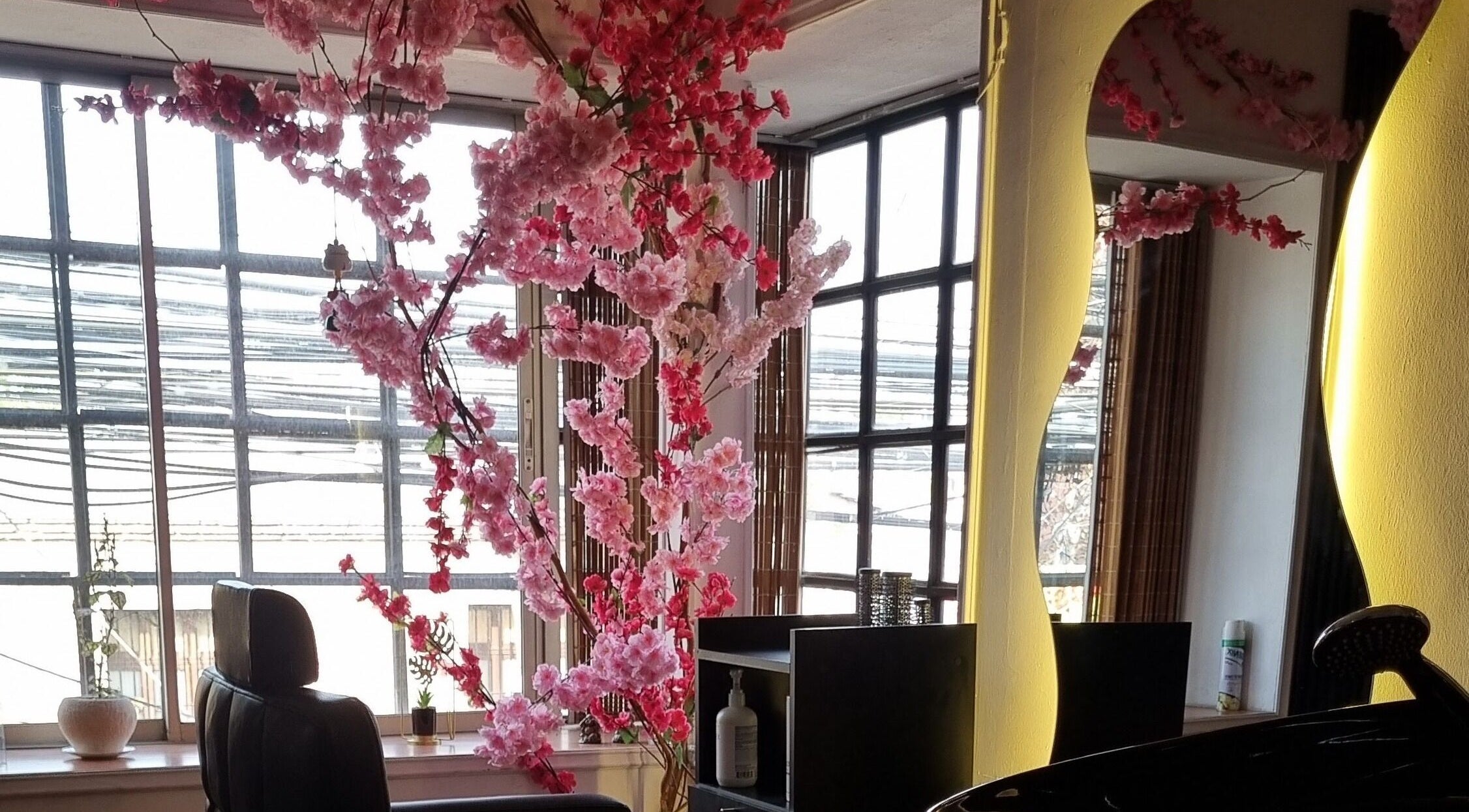 Interior de Sily Beauty Brand en San Miguel, Región Metropolitana, CL con flores rosadas decorativas y espejo elegante.