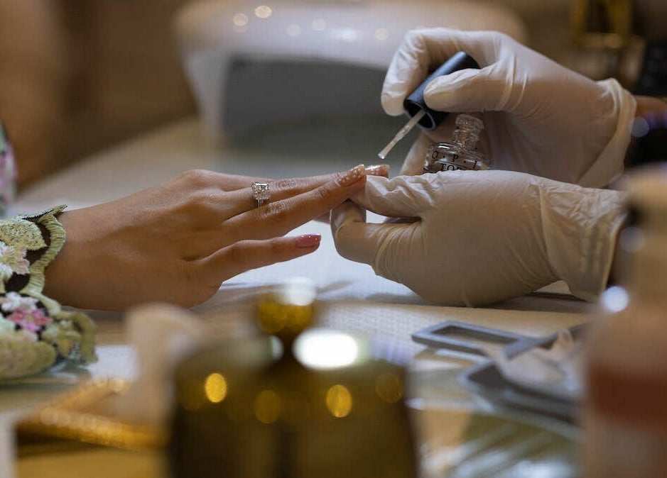 Nail technician applying polish at Mermaid Salon Ghornata in Riyadh, Riyadh Province, SA.