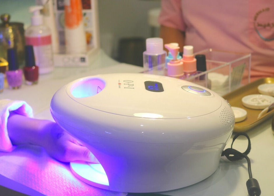Nail treatment at Mermaid Salon Ghornata, Riyadh, Riyadh Province, SA with a hand in a UV lamp.