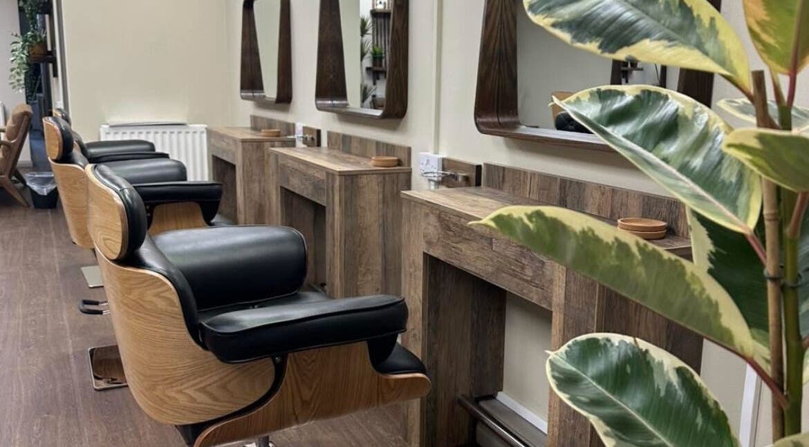 Stylish interior of Navie studio in Hull, England, GB featuring chic wooden salon chairs and mirrors.