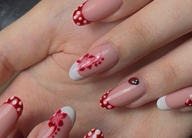 Elegant nail art with red polka dots and floral designs at Lunar Beauty in Huthwaite, England, GB.