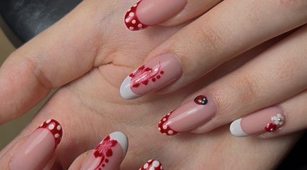 Elegant nail art with red polka dots and floral designs at Lunar Beauty in Huthwaite, England, GB.
