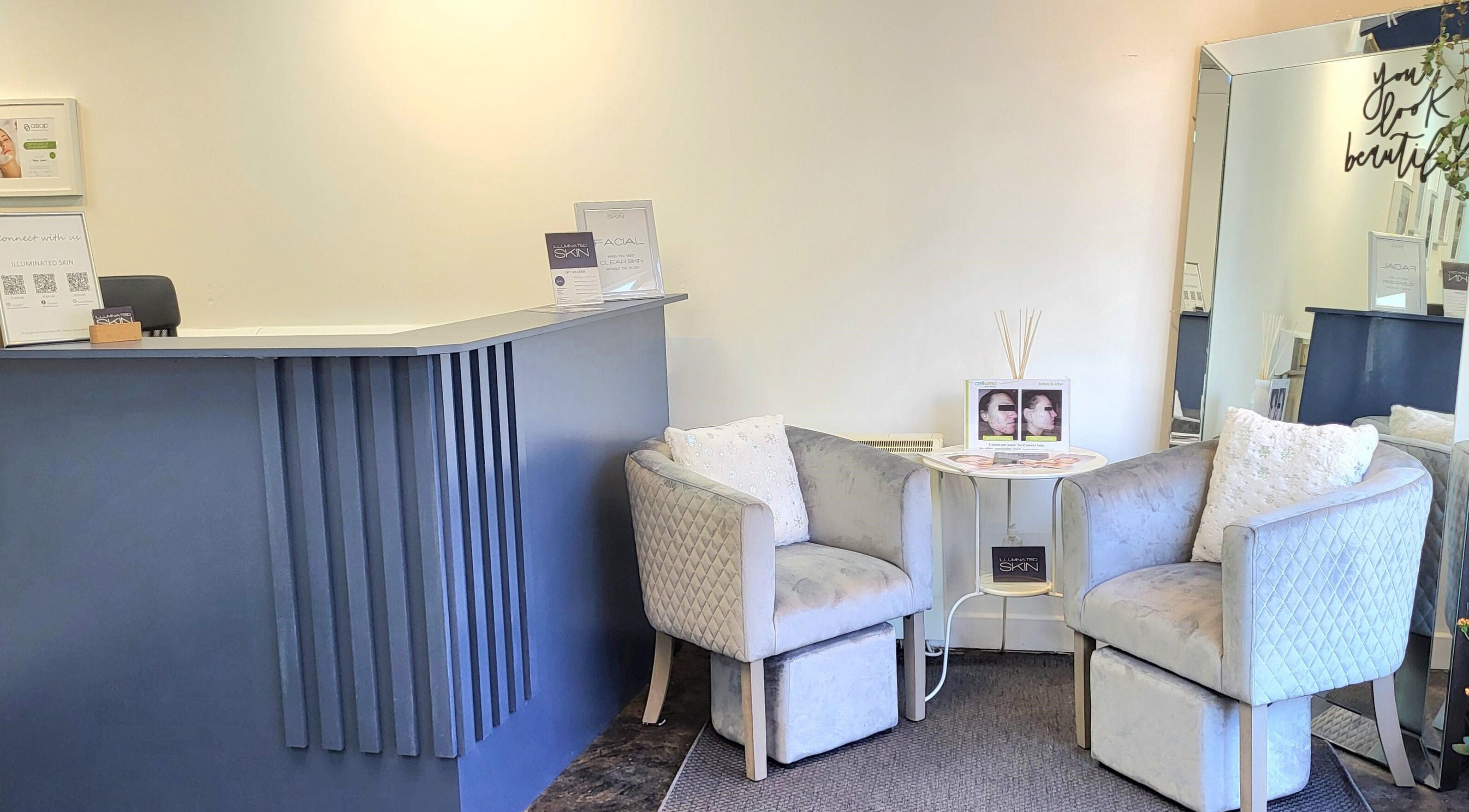 Cozy reception area at Illuminated Skin in Ardee, IE with plush chairs and elegant decor.