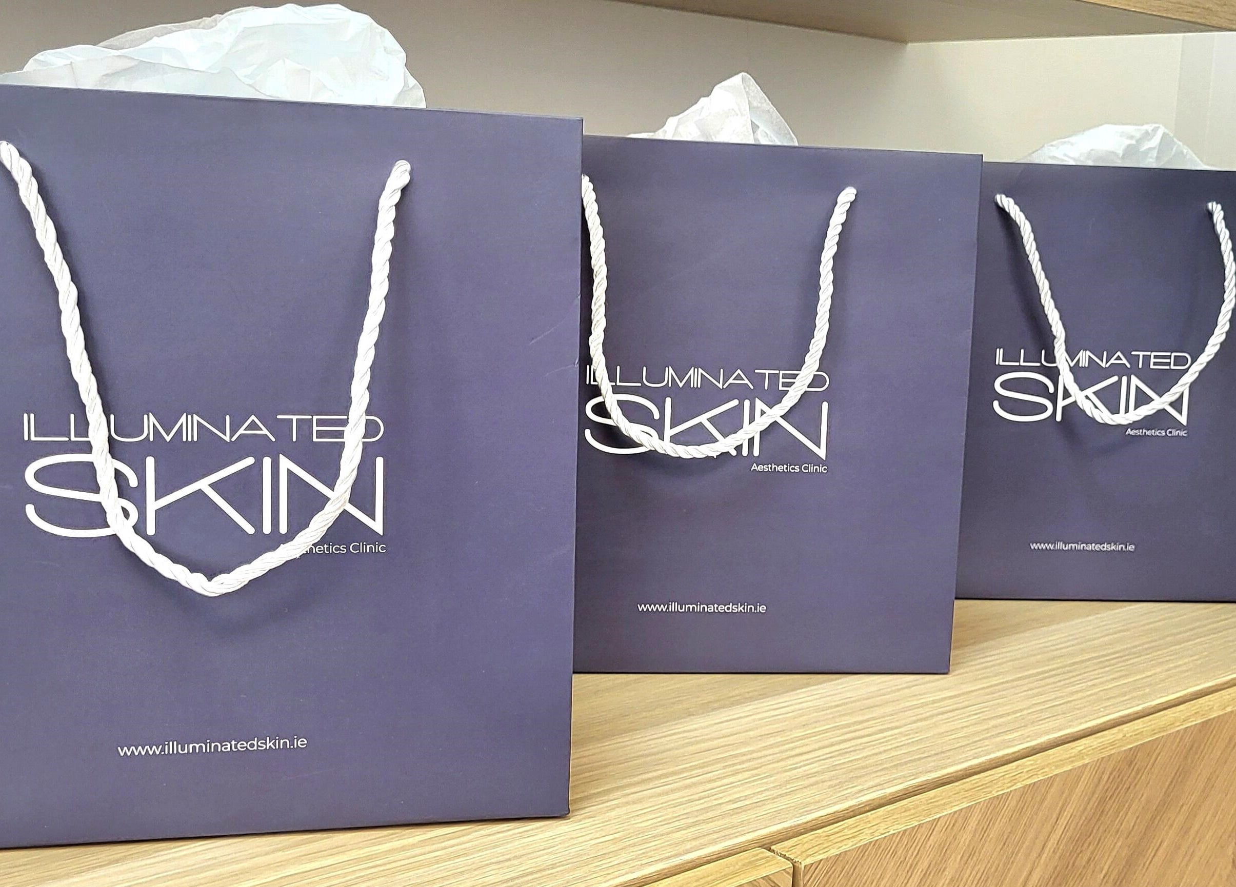 Elegant gift bags with Illuminated Skin logo at Ardee, IE, showcasing sophisticated style and branding.
