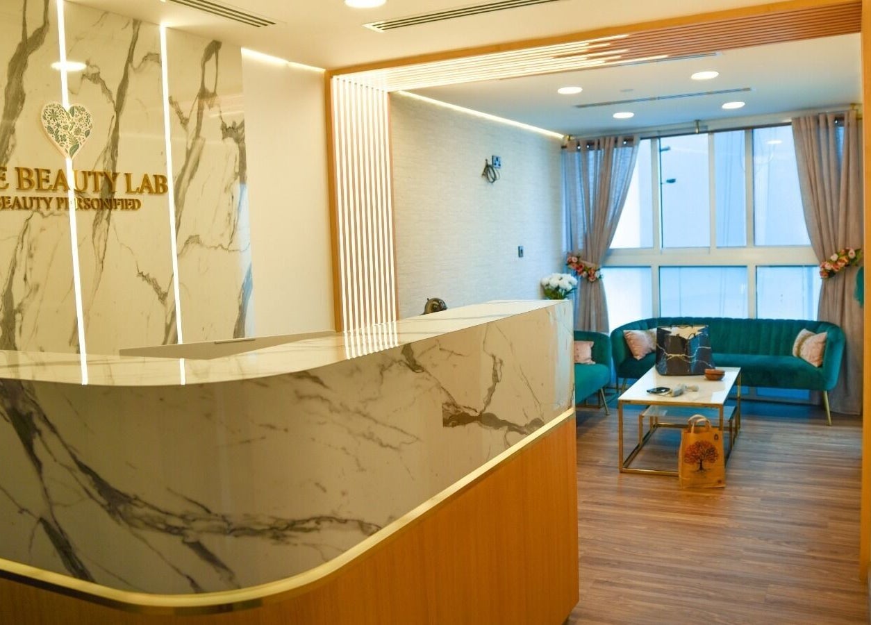 Reception area at The Beauty Lab Ladies Salon in Abu Dhabi, AE featuring marble decor and cozy seating.
