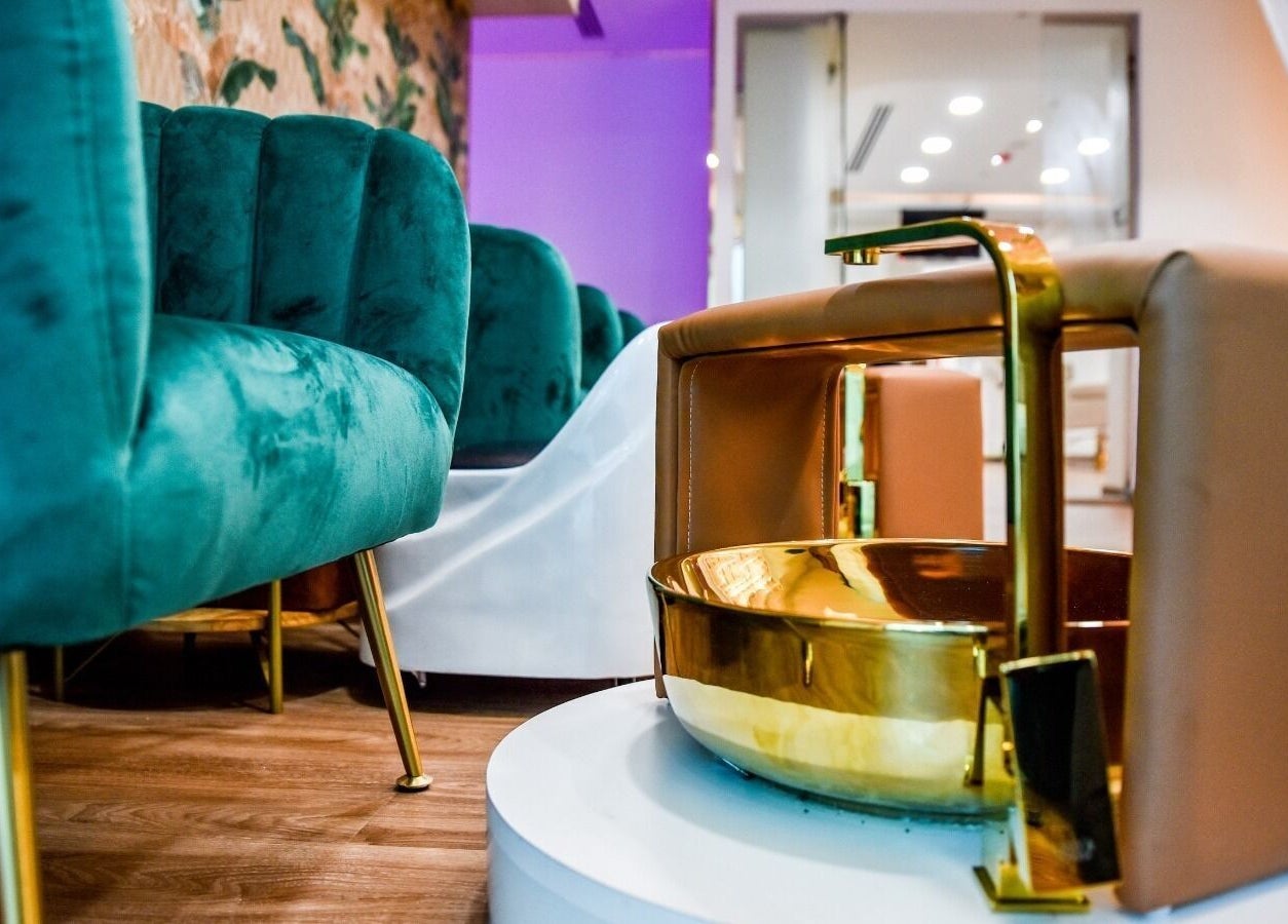 Luxurious foot spa setup at The Beauty Lab Ladies Salon in Abu Dhabi, AE with plush chairs and a golden basin.