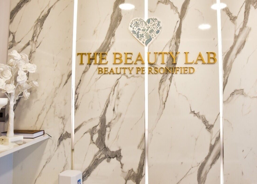 Reception area of The Beauty Lab Ladies Salon in Abu Dhabi, AE with a white marble wall and decor.