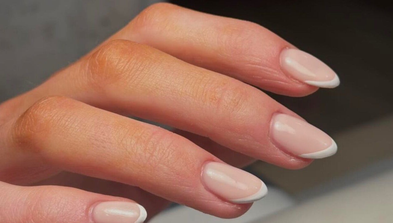 Elegant French manicure at KMbeauty, Ebbw Vale, Wales, GB showcasing classic nail art.