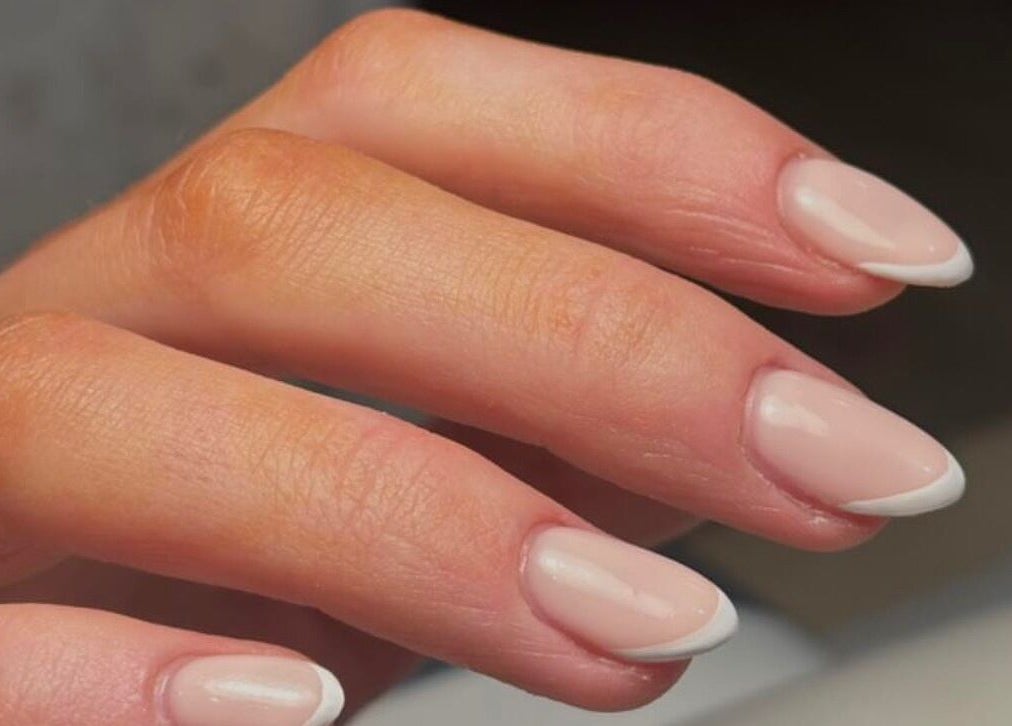Elegant French manicure at KMbeauty, Ebbw Vale, Wales, GB showcasing classic nail art.