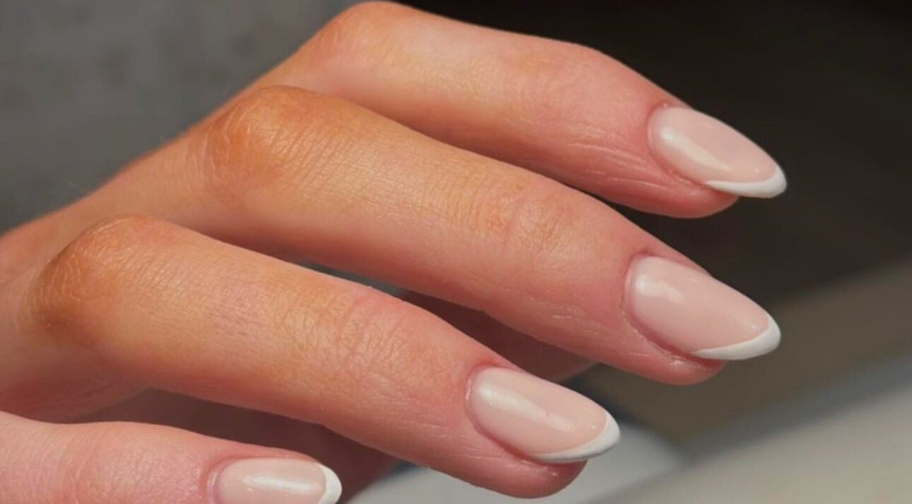 Elegant French manicure at KMbeauty, Ebbw Vale, Wales, GB showcasing classic nail art.