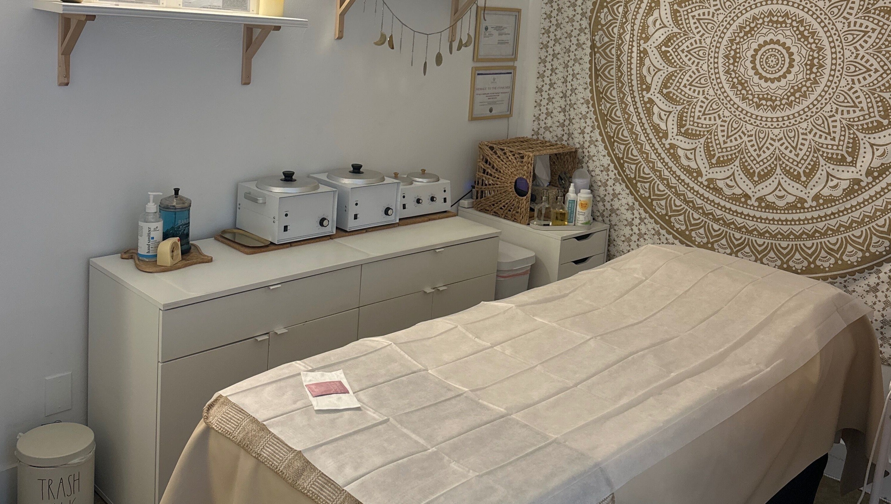 Serene treatment room at SB Artistry, Costa Mesa, California with soothing decor and a massage table.