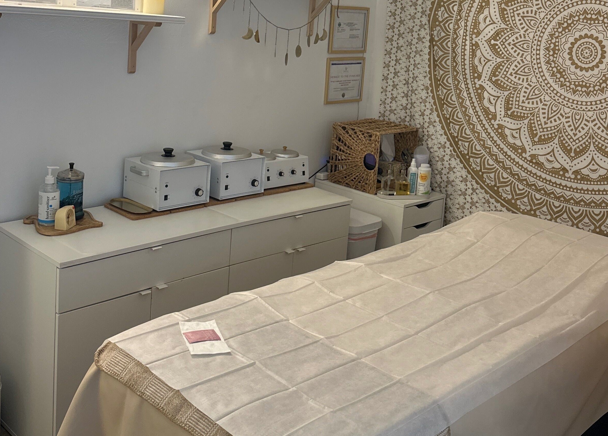 Serene treatment room at SB Artistry, Costa Mesa, California with soothing decor and a massage table.